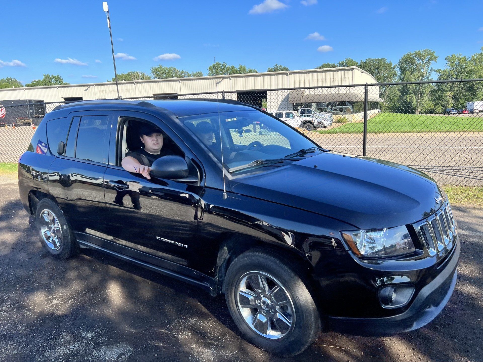 A man is sitting in the driver 's seat of a black jeep.