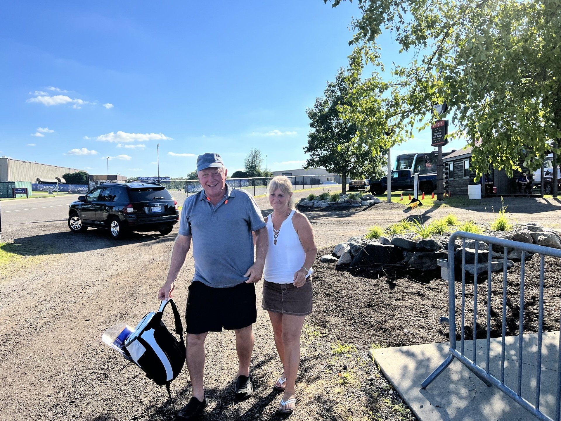 A man and a woman are standing next to each other in a parking lot.