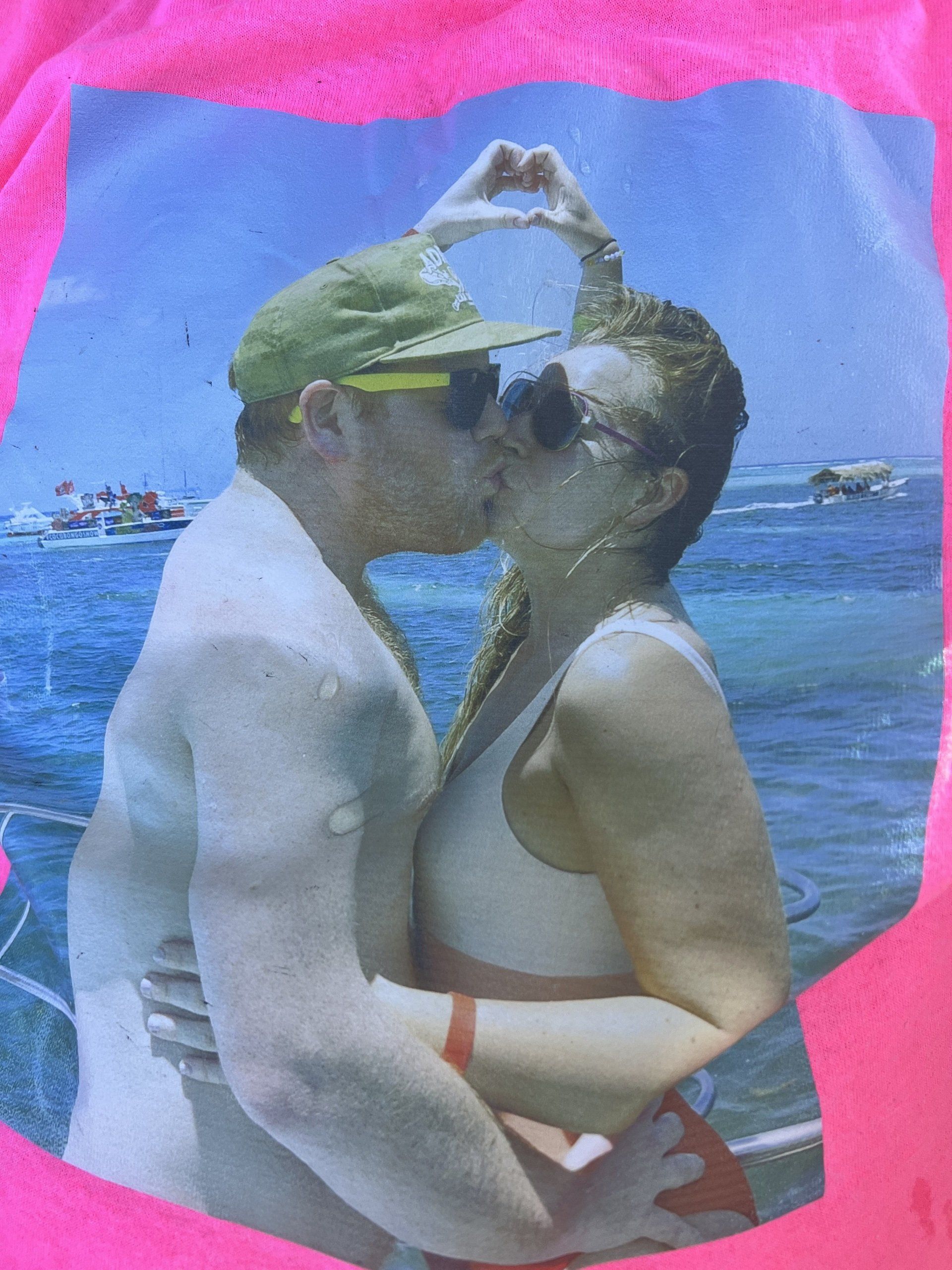 A man and a woman are kissing on a boat in the ocean.