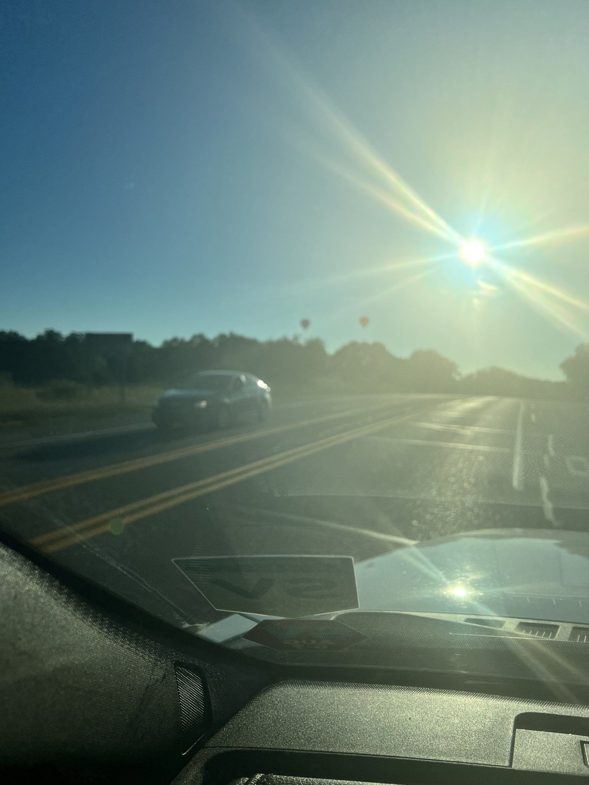 The sun is shining through the windshield of a car