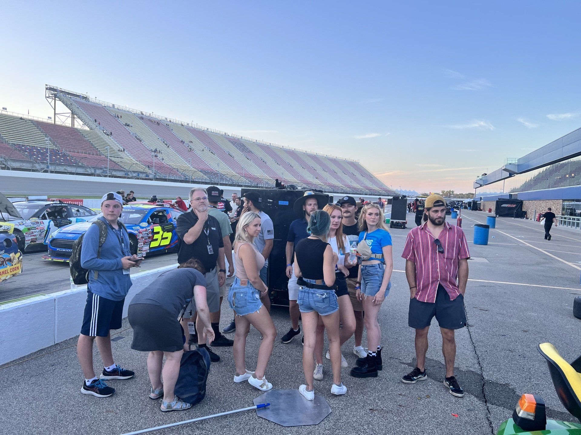 A group of people are standing around a race track.