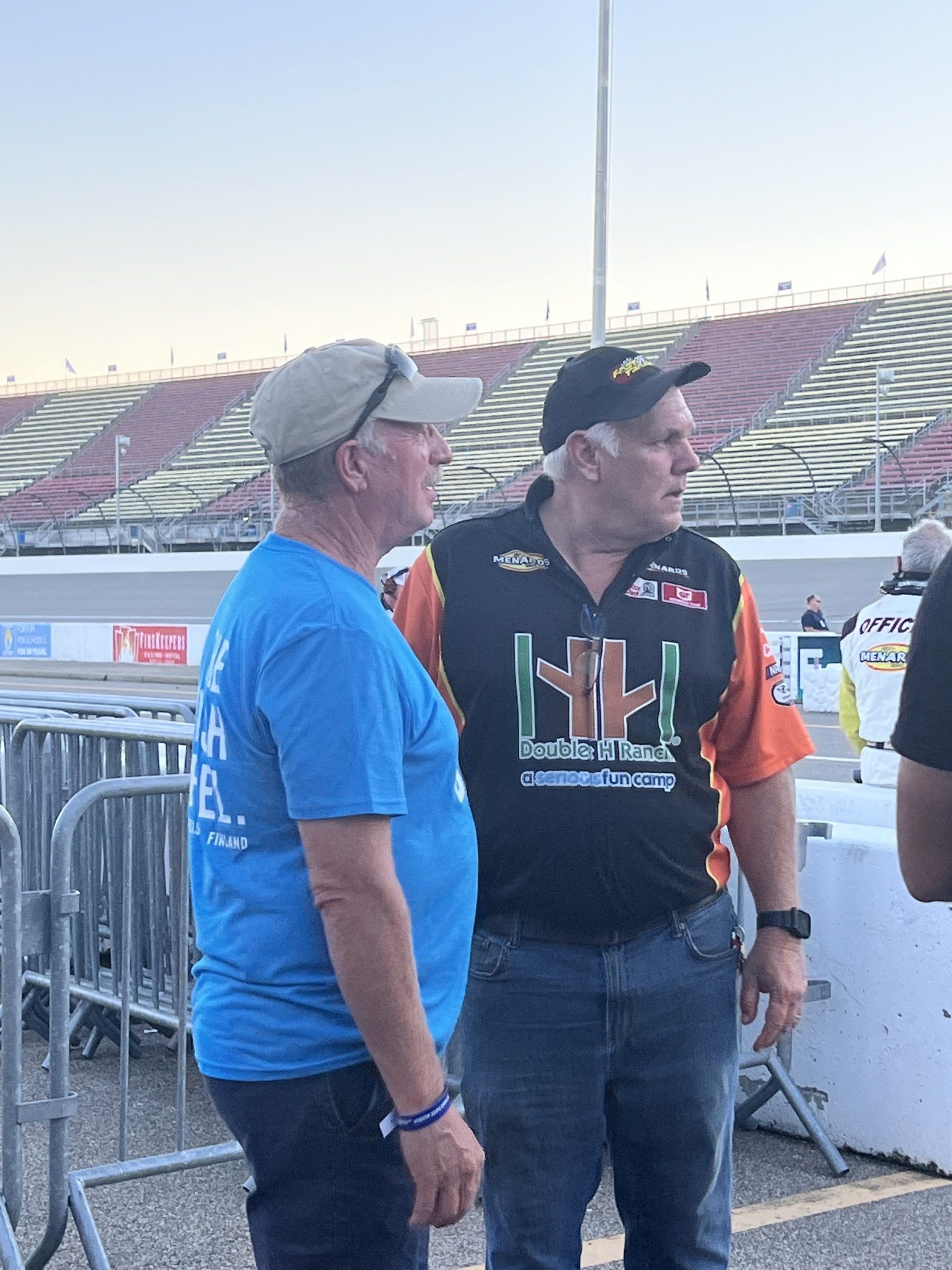 Two men are standing next to each other and one of them is wearing a shirt that says bkl