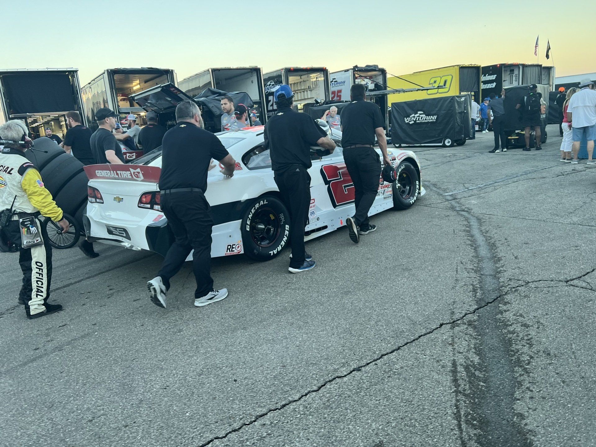 A group of people are pushing a race car on a track