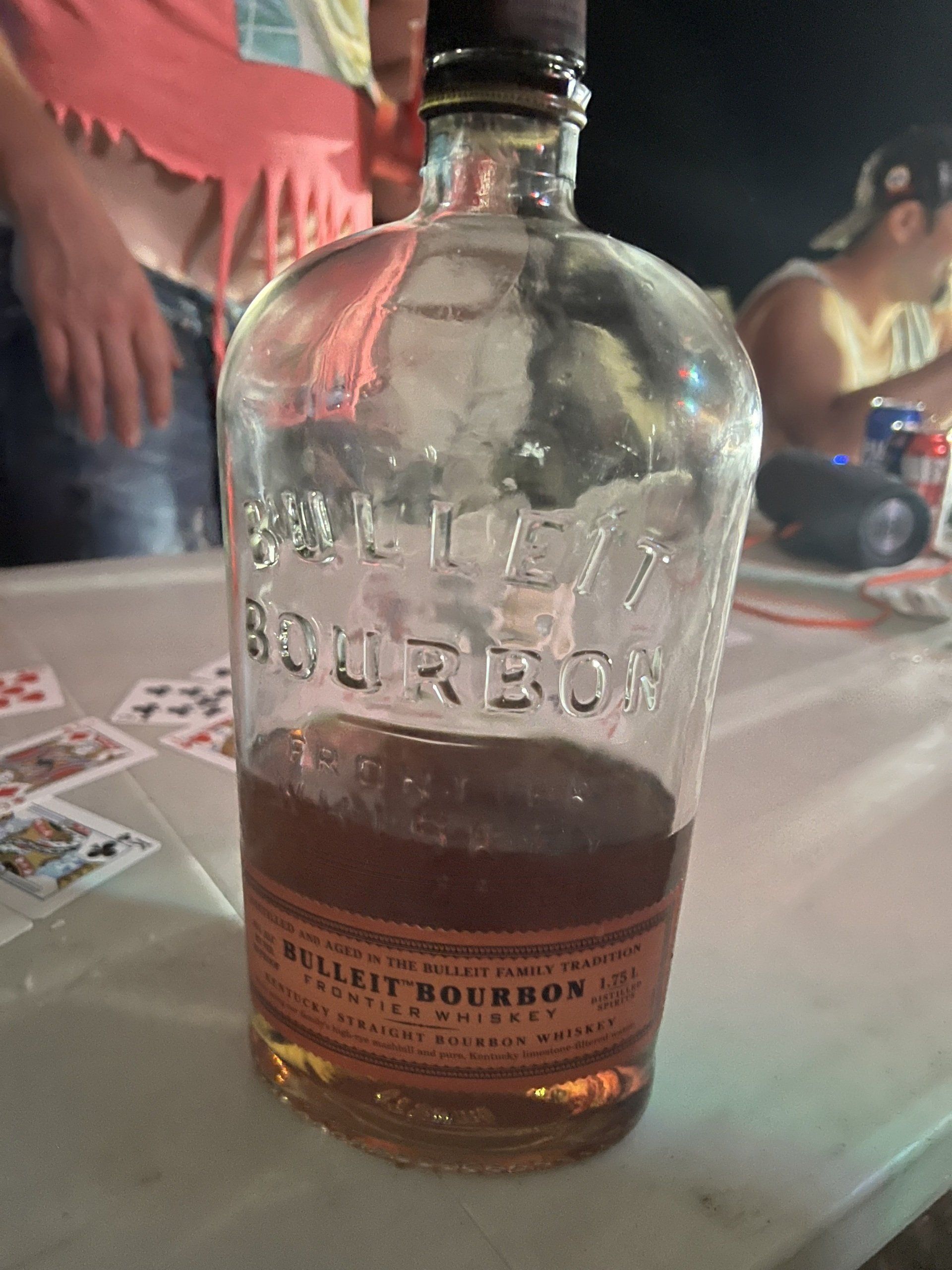 A bottle of bulleit bourbon sits on a table