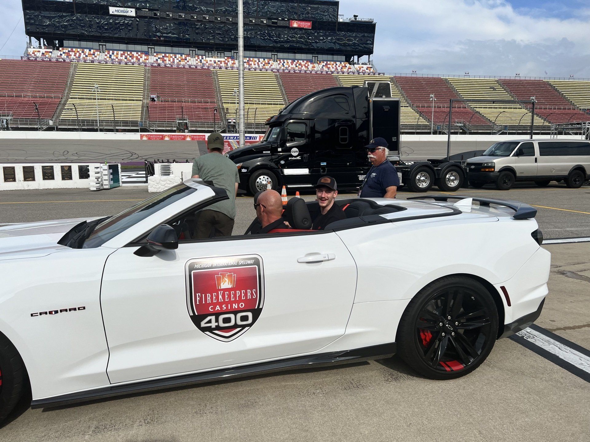 A group of people are sitting in a white convertible car.