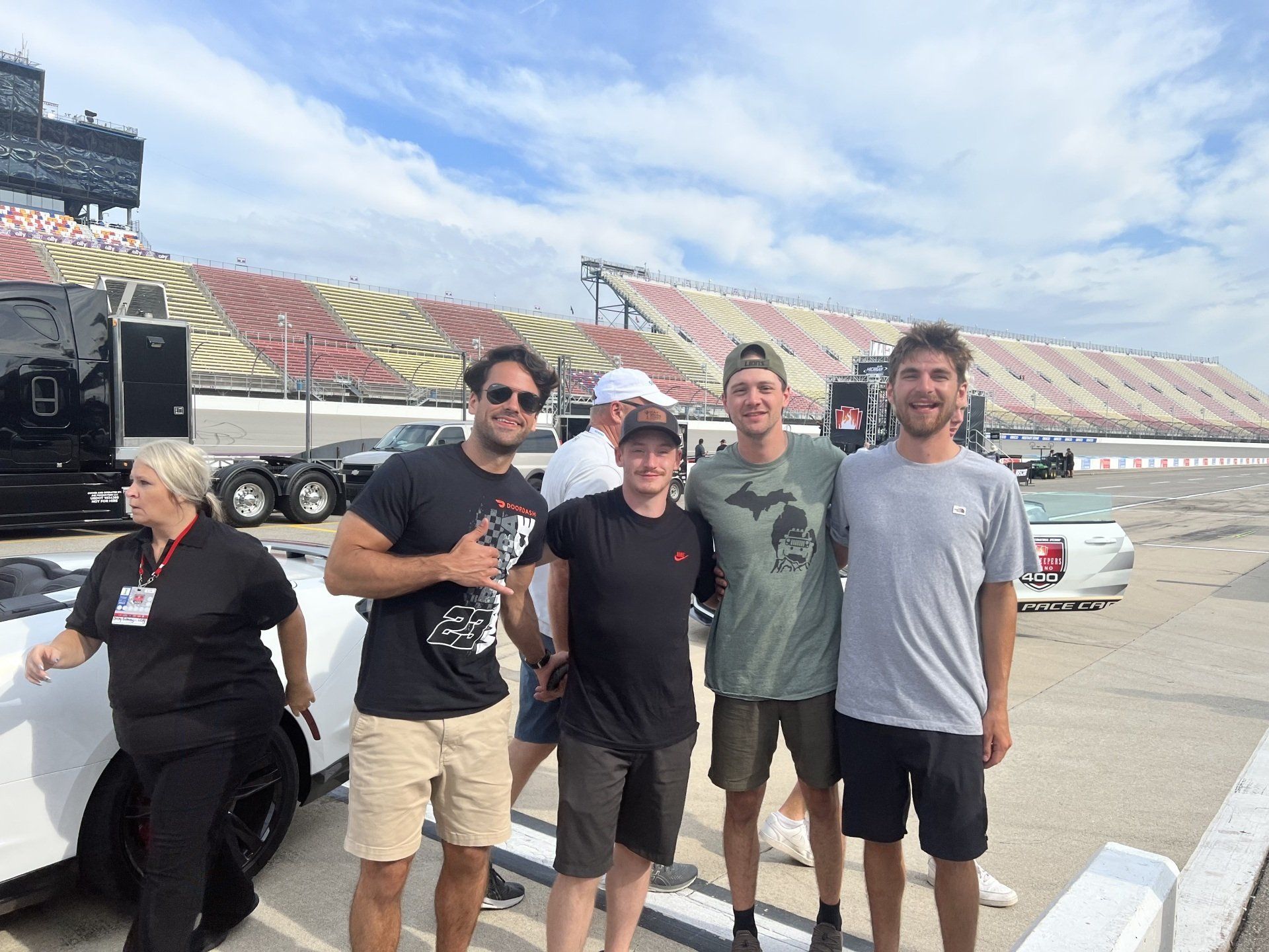 A group of people are posing for a picture in front of a race track.