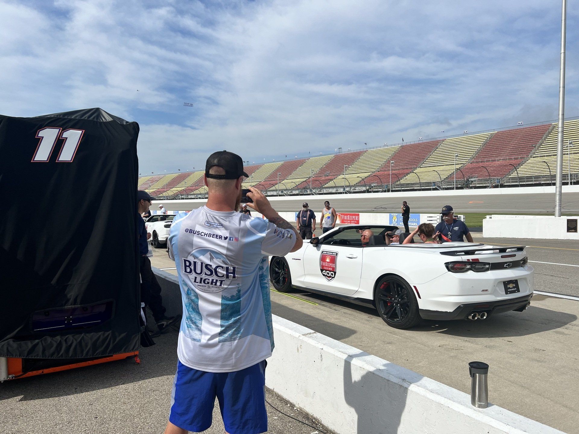A man is taking a picture of a race car on a race track.