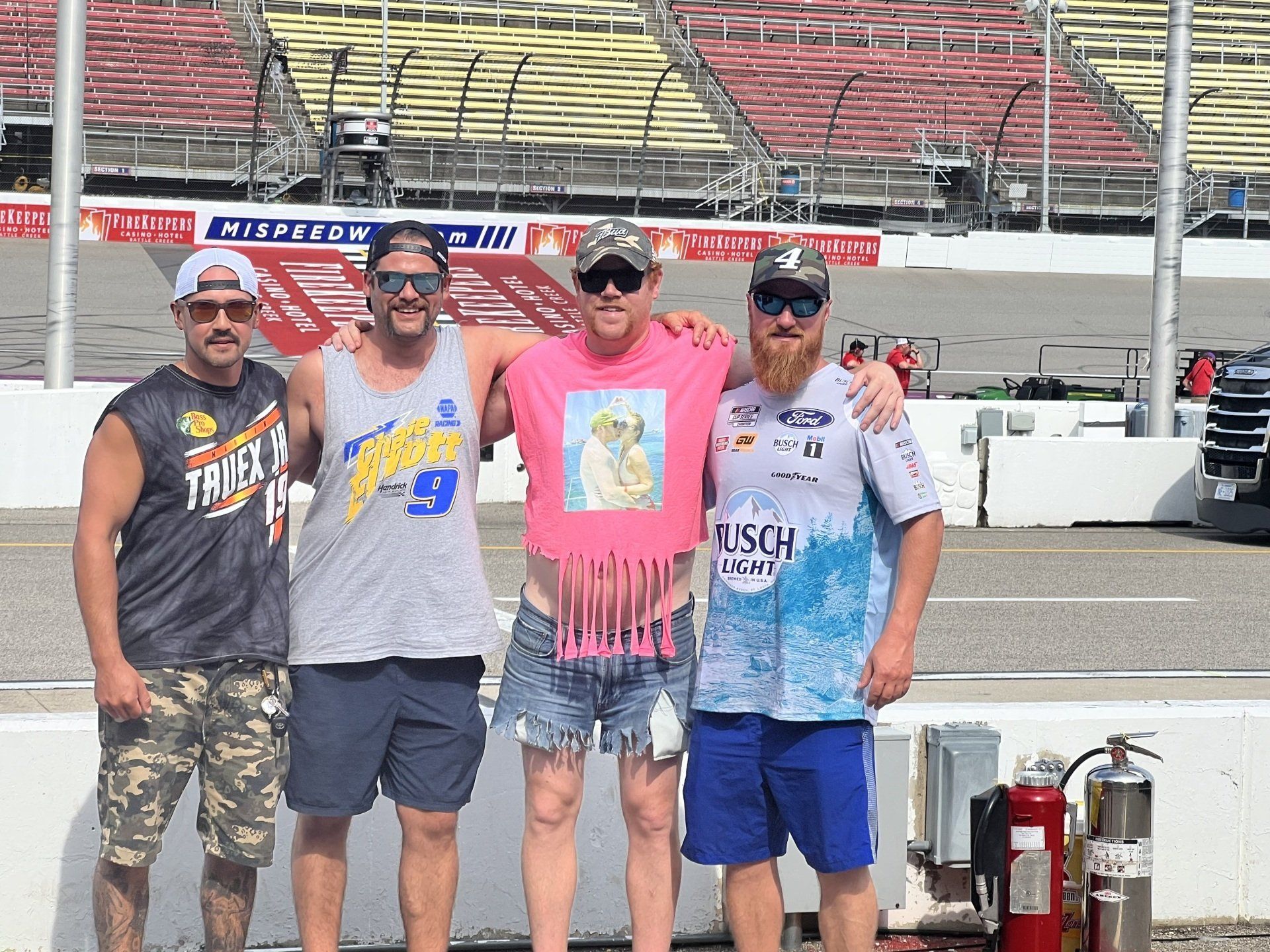 A group of men are posing for a picture on a race track.