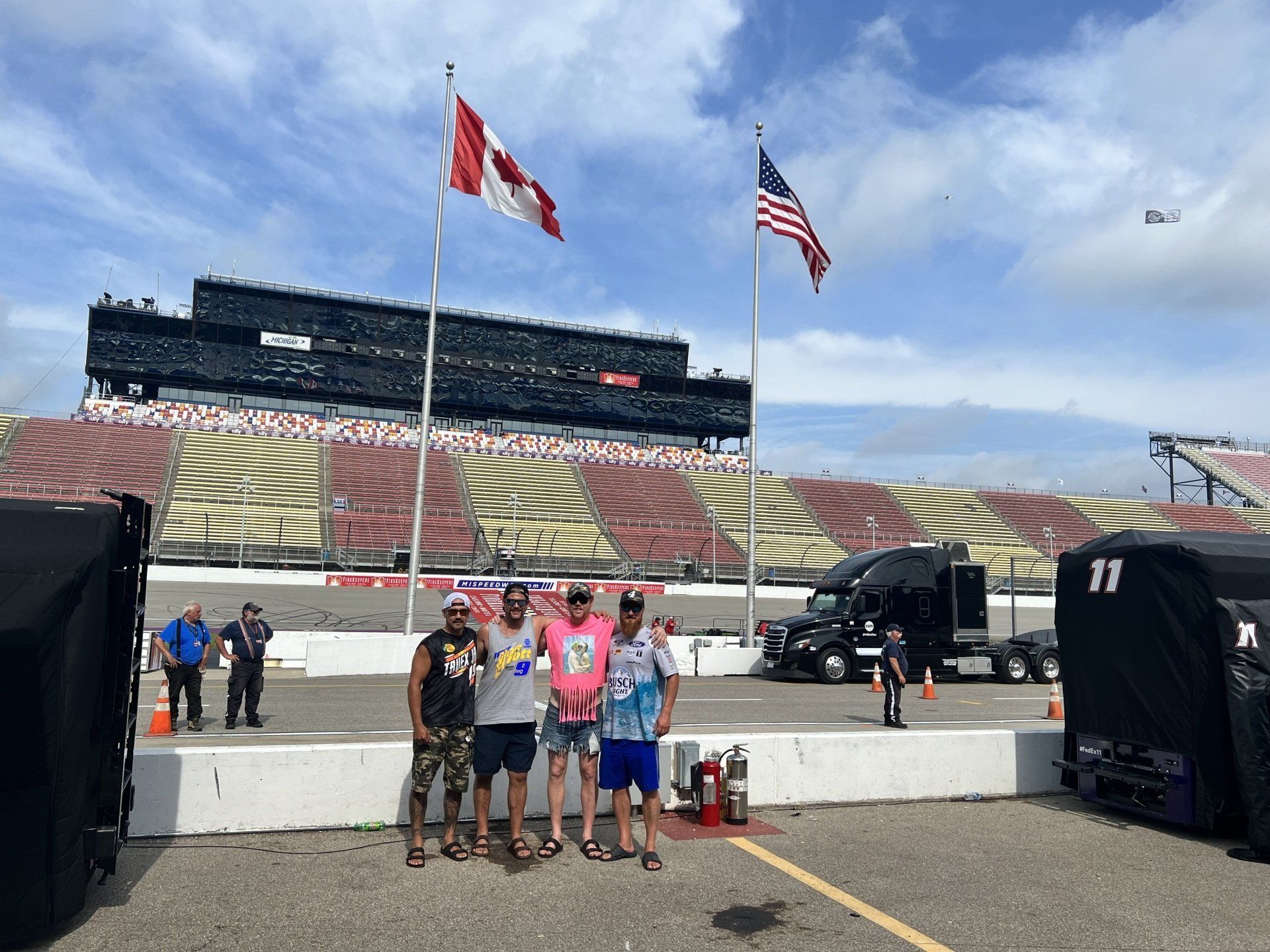 A group of people are posing for a picture in front of a race track.