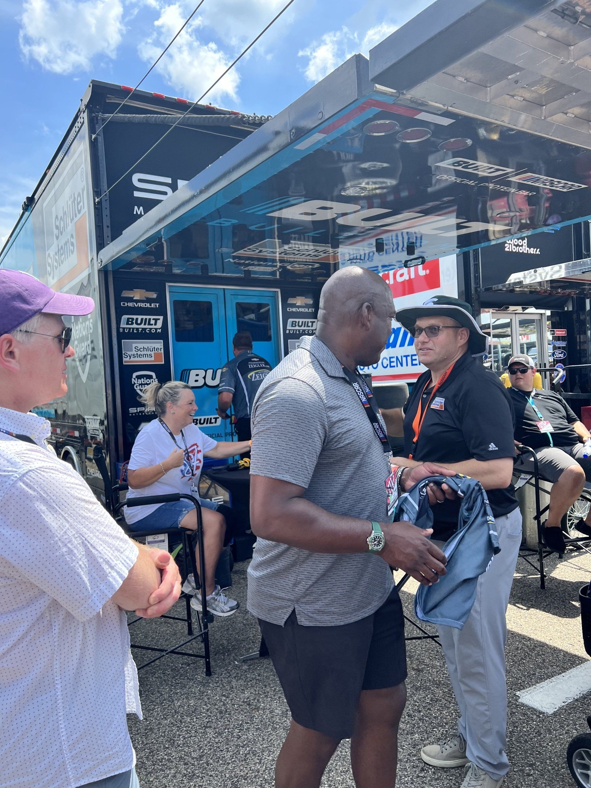 A group of people are standing in front of a trailer.