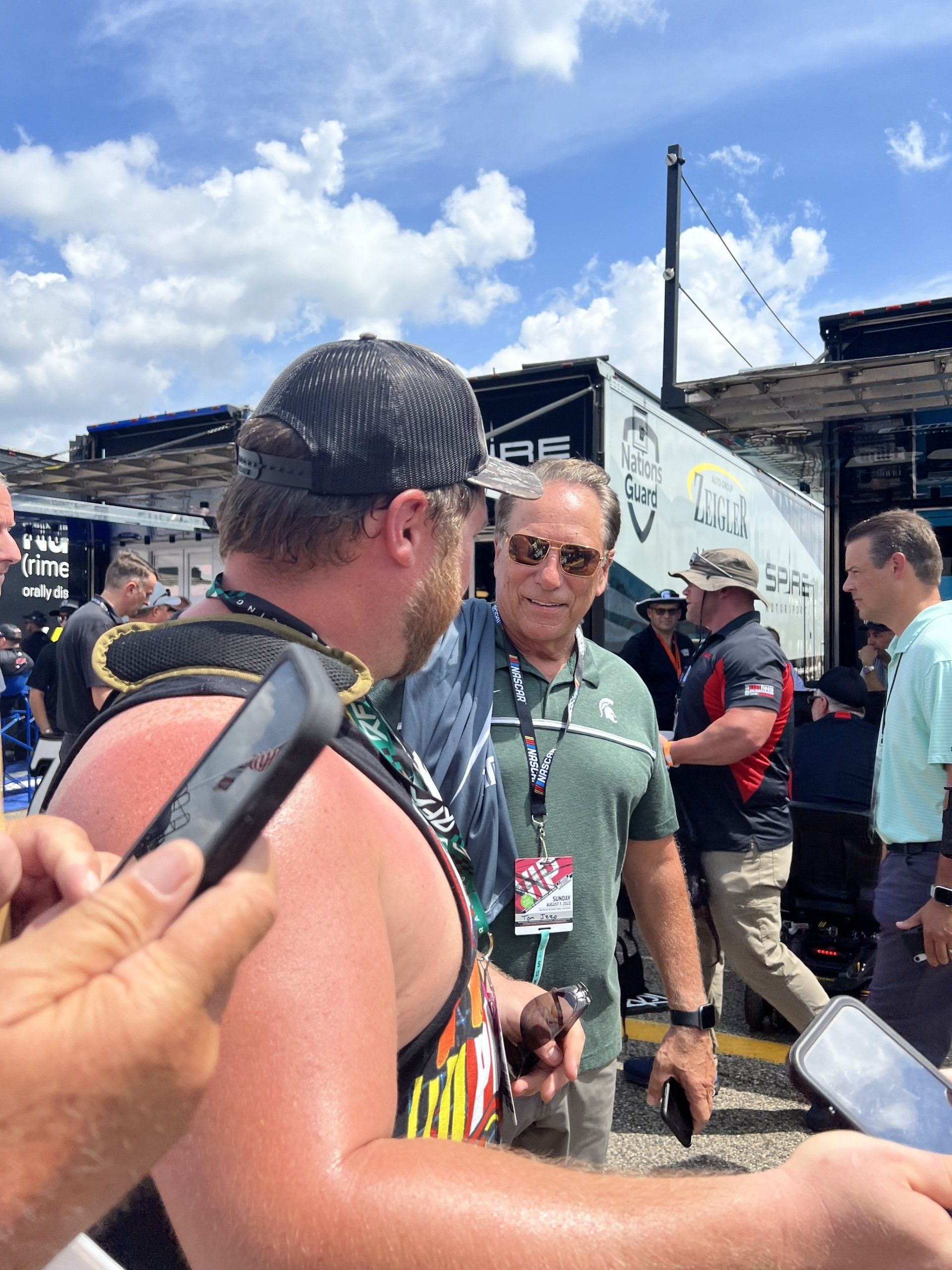 A man is talking to another man in front of a truck that says sprint