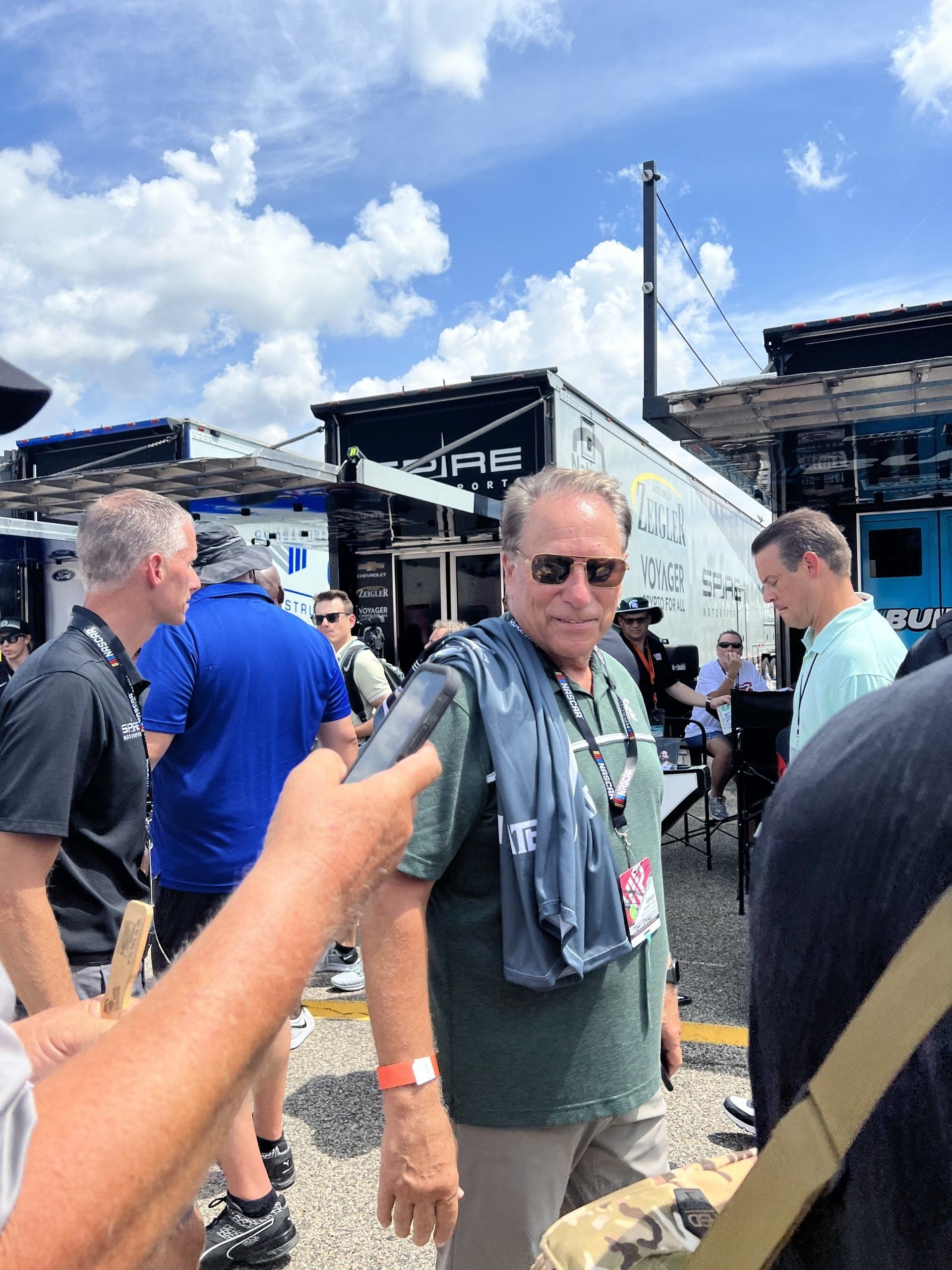A man wearing sunglasses is being interviewed by a reporter
