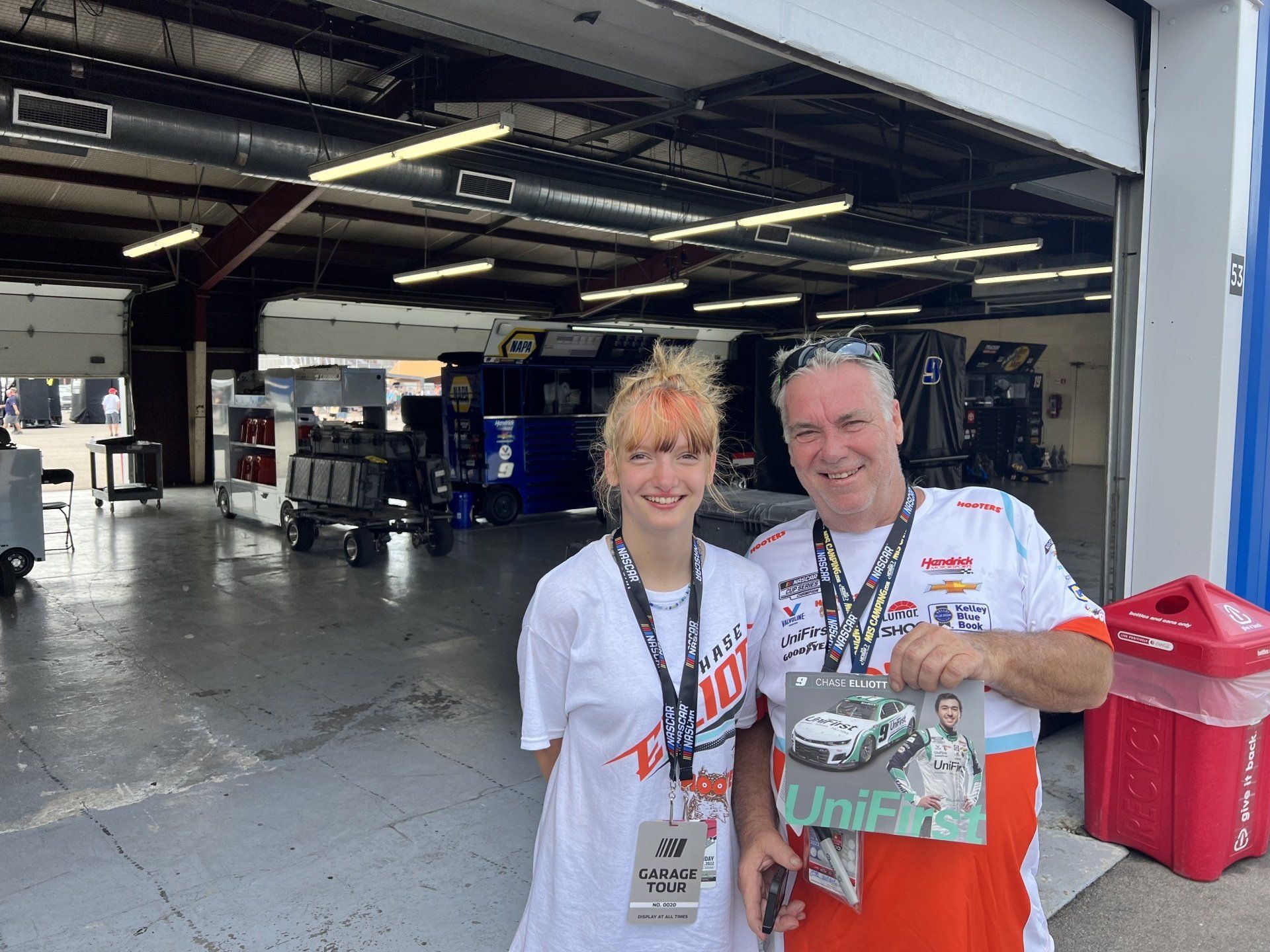 A man and a woman are posing for a picture in a garage.