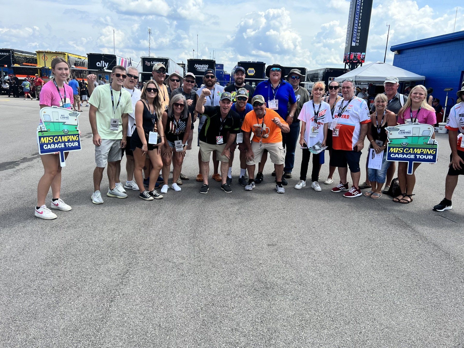 A group of people are posing for a picture in a parking lot.