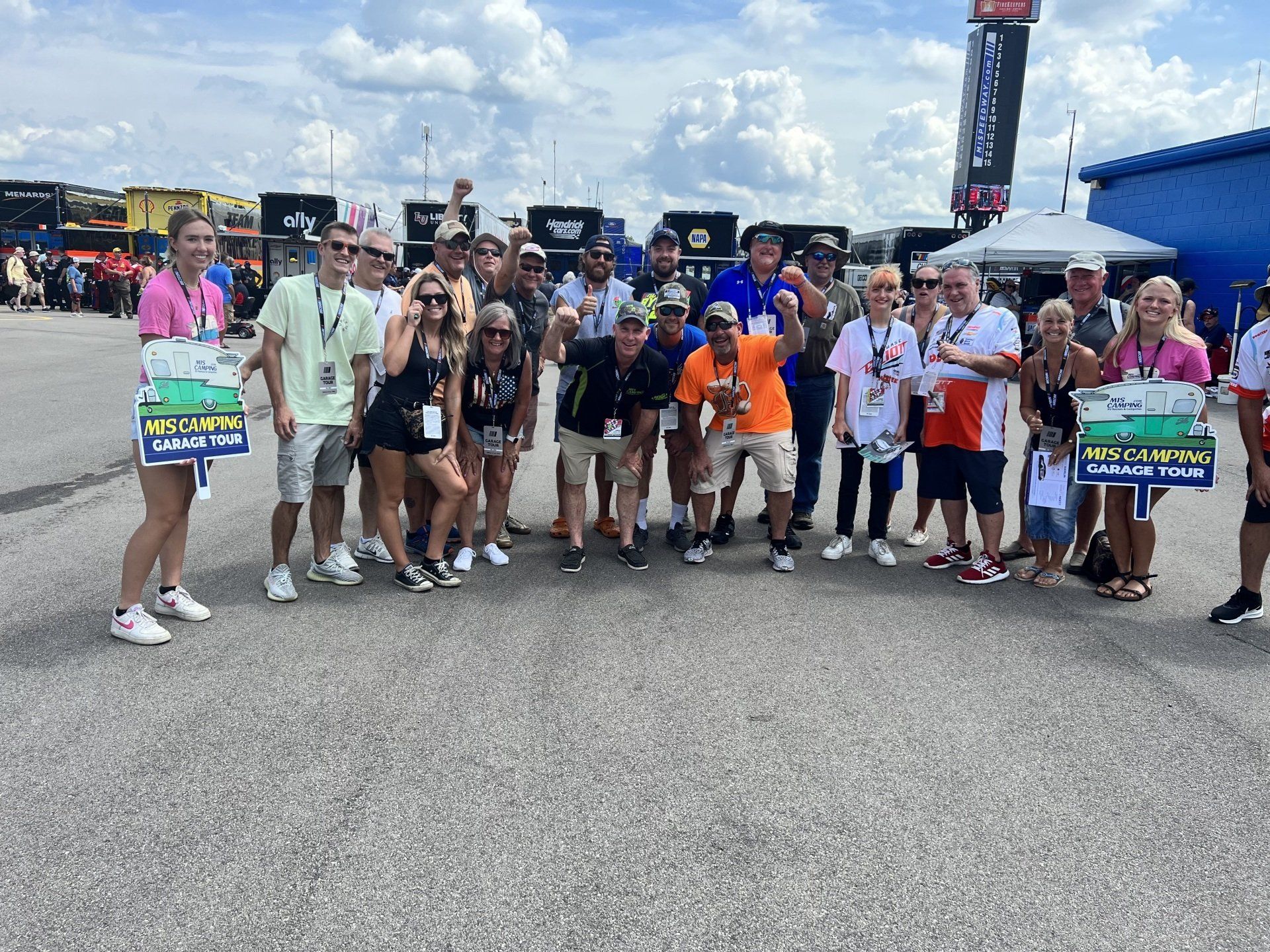 A group of people are posing for a picture in a parking lot.