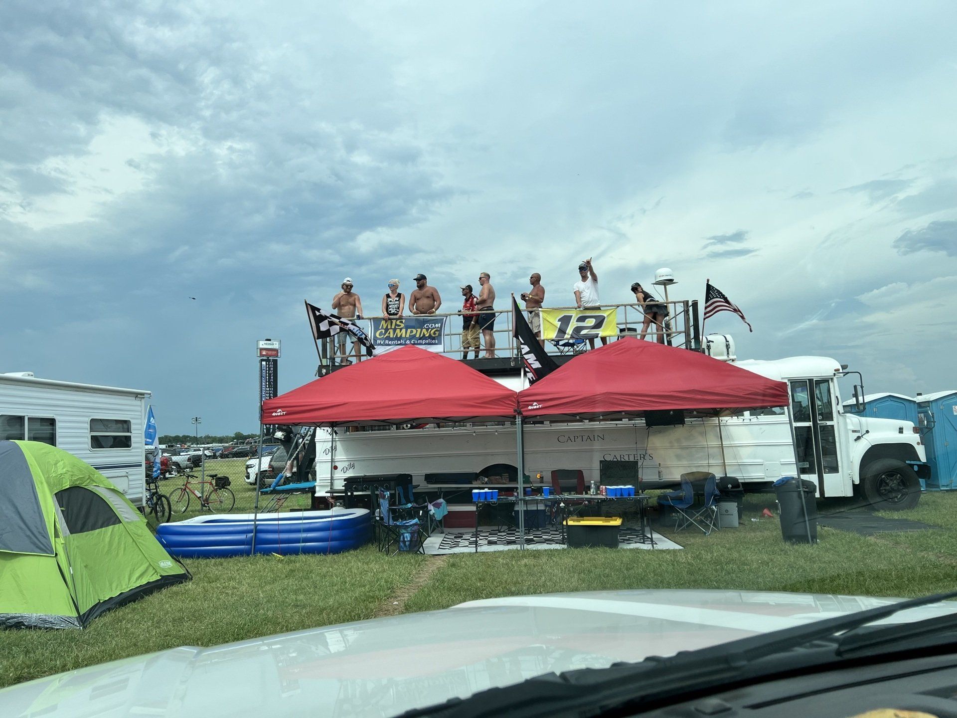 A group of people are standing on top of a stage in a field.