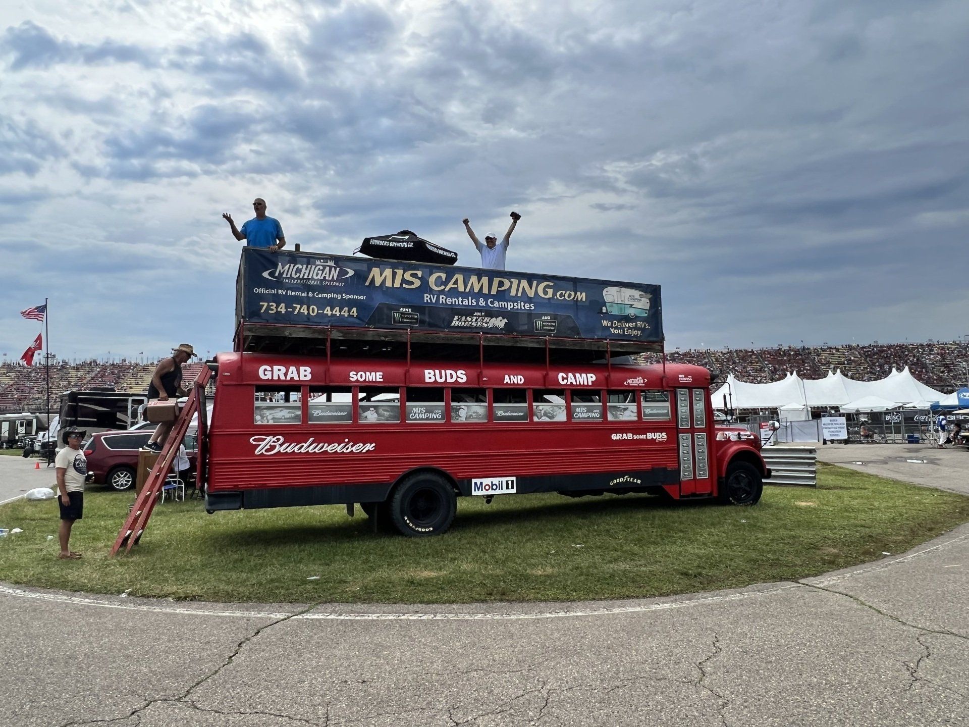 A red bus with a sign on top that says mis camping