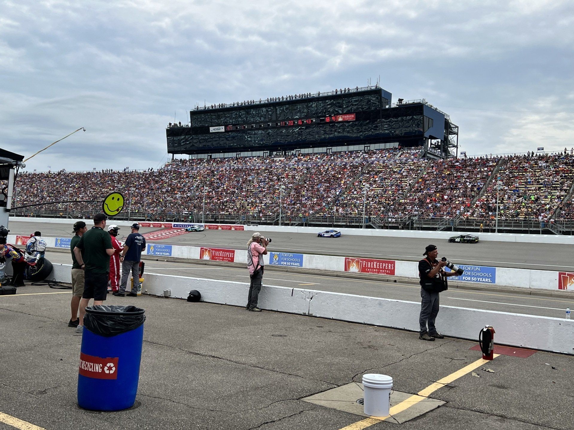 A crowd of people are watching a race at a race track.
