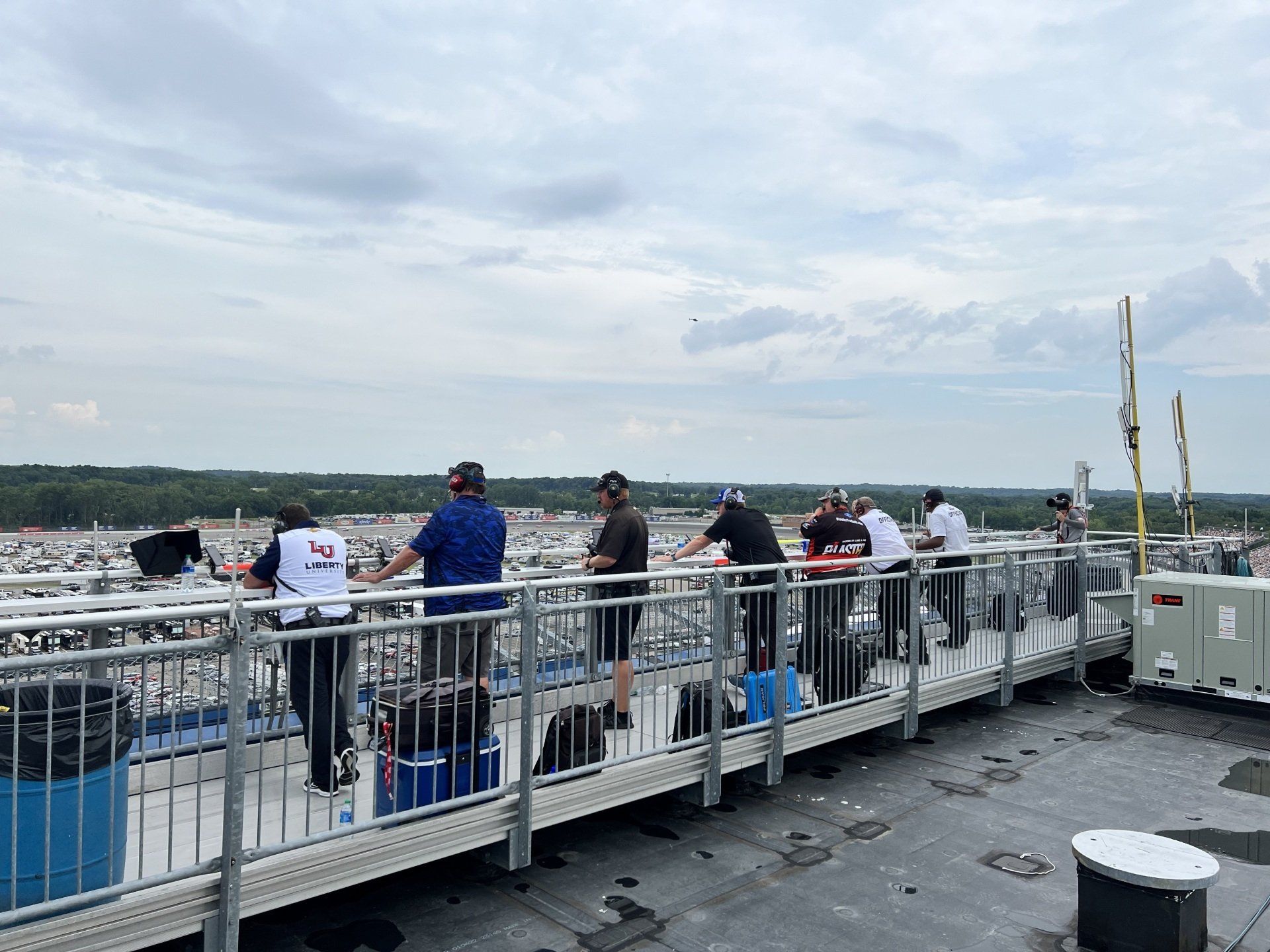 A group of people are standing on a balcony looking out over a city.