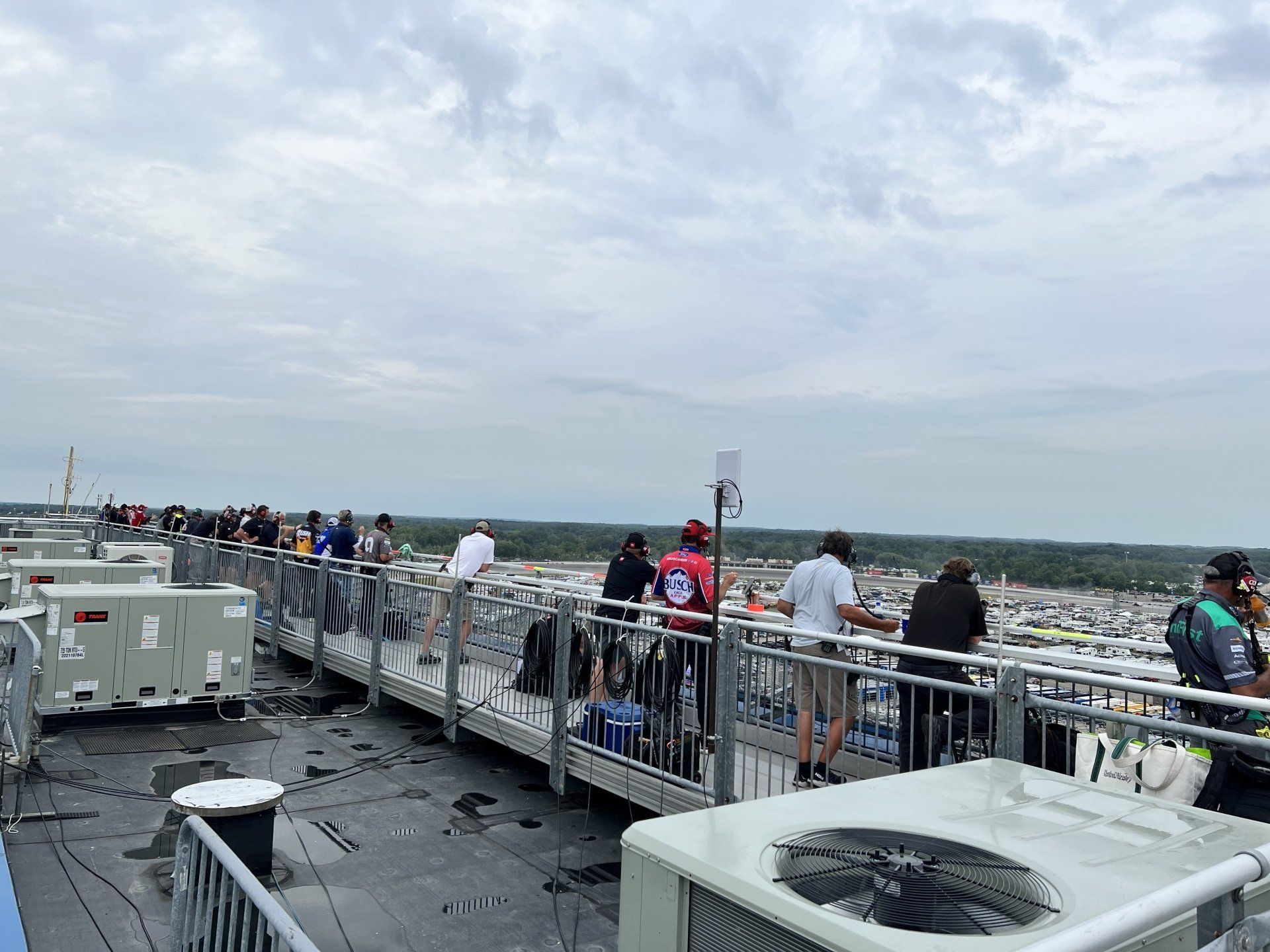 A group of people are standing on top of a building looking out over a city.