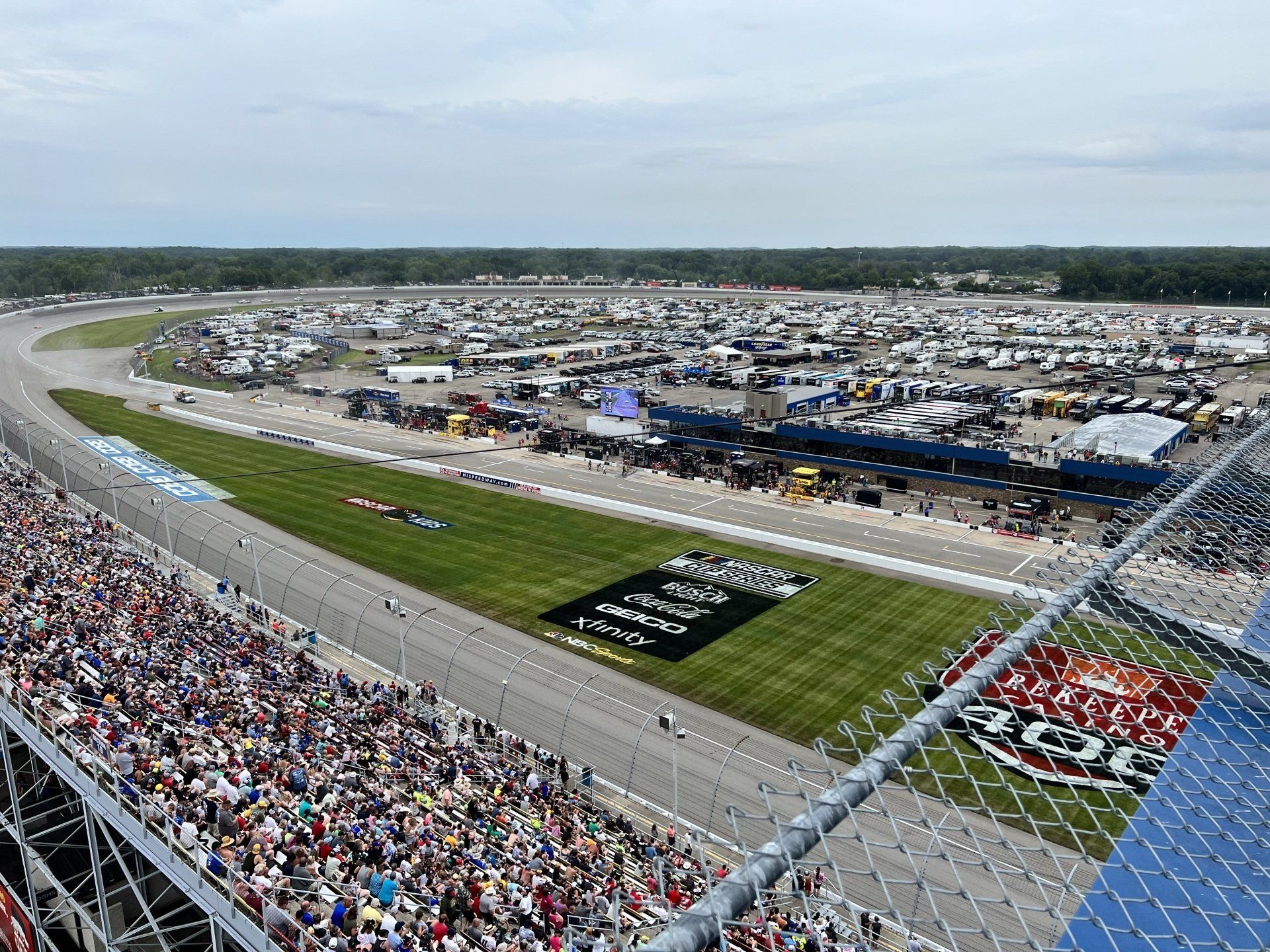 An aerial view of a race track filled with people watching a race.