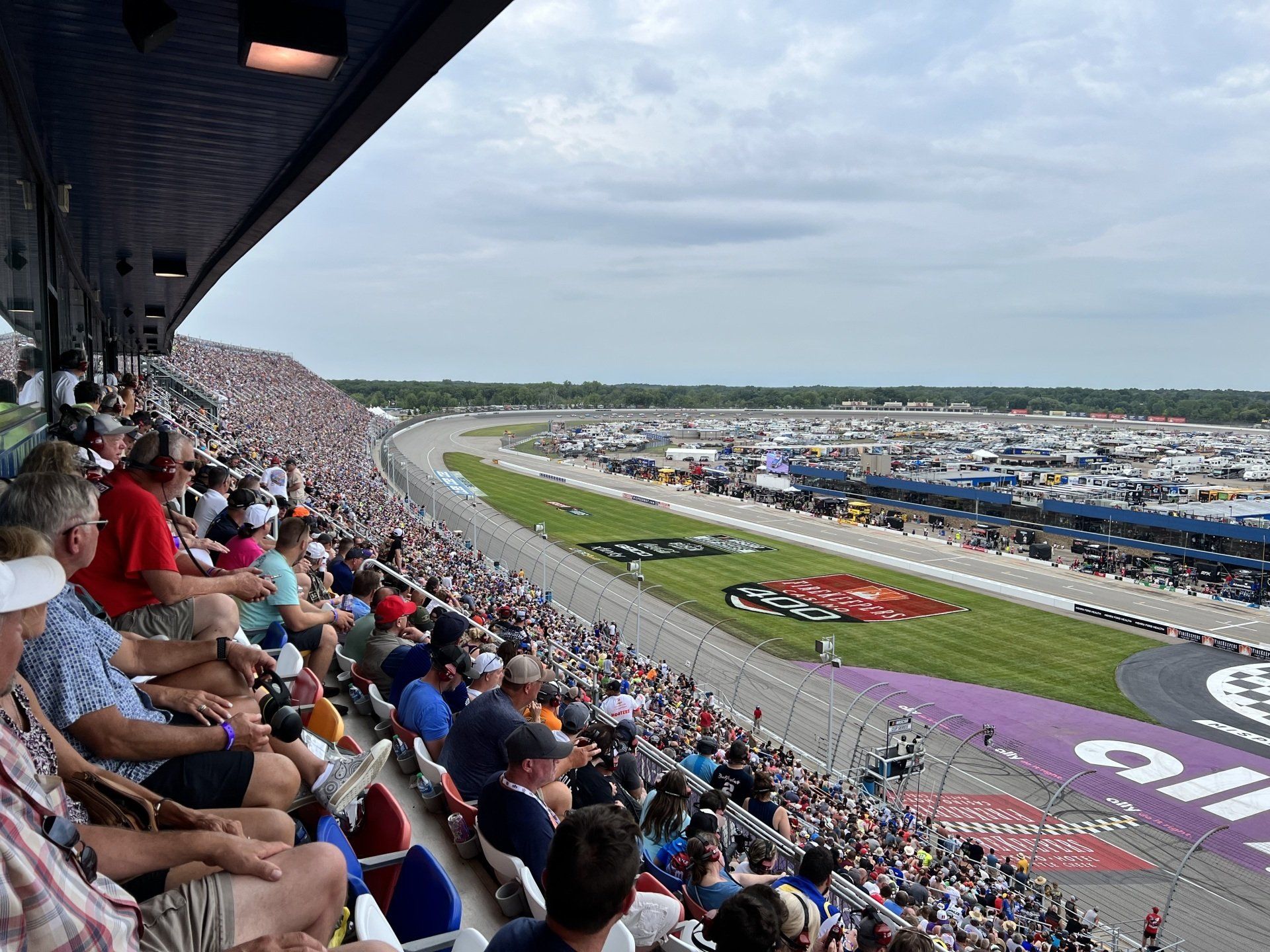 A crowd of people are sitting in a stadium watching a race.