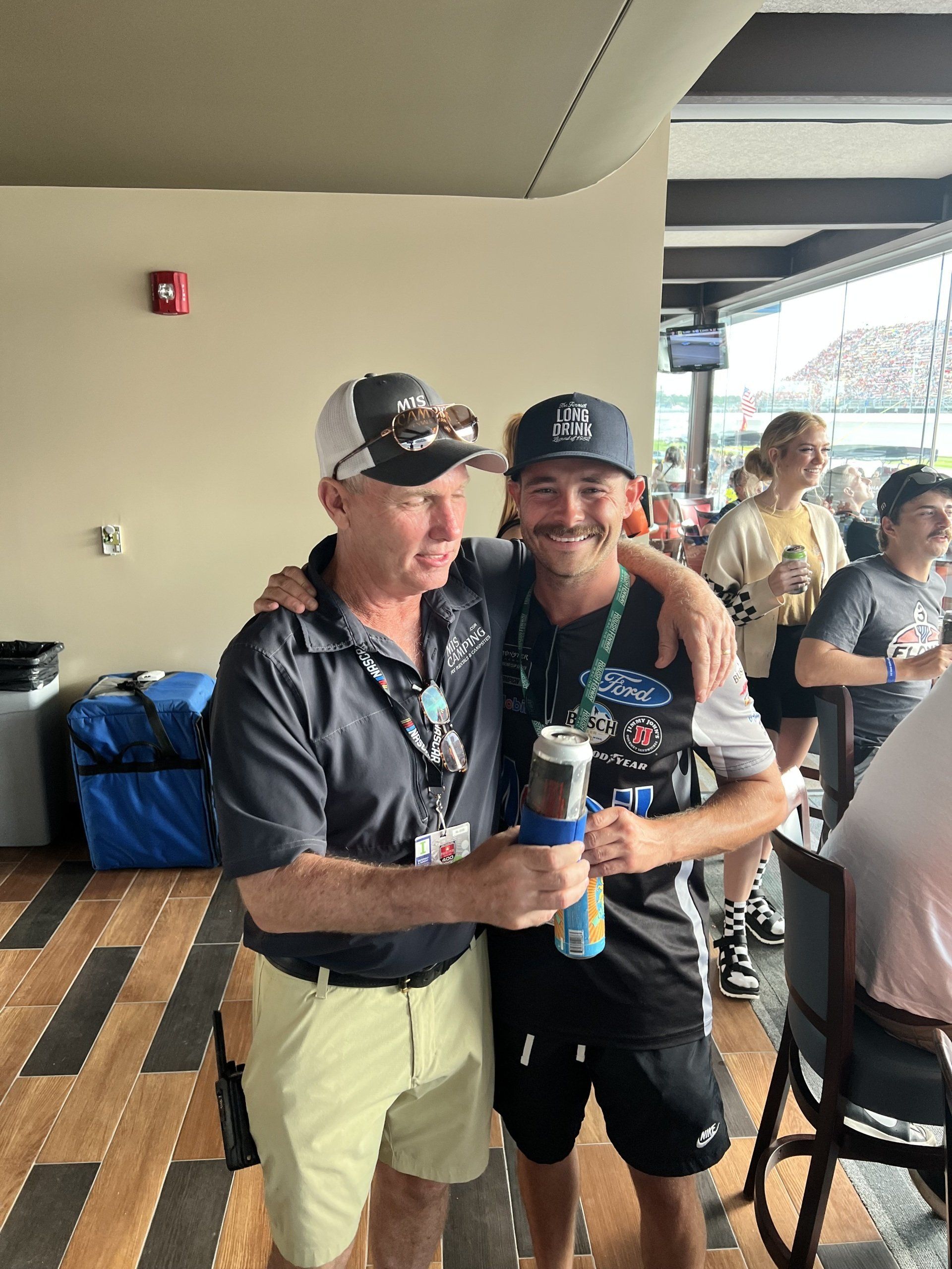 Two men are standing next to each other in a room.