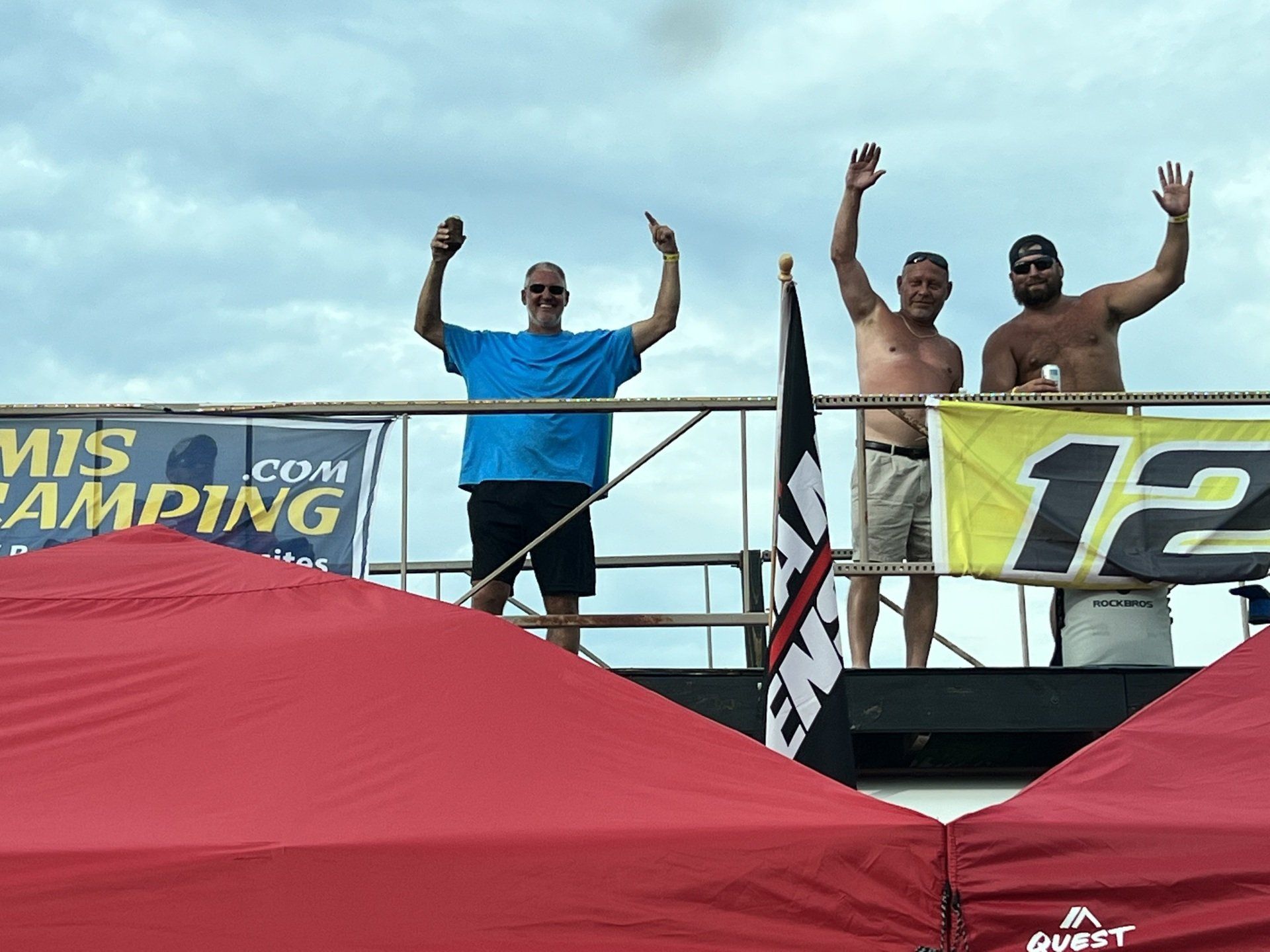 A group of men standing in front of a banner that says 12