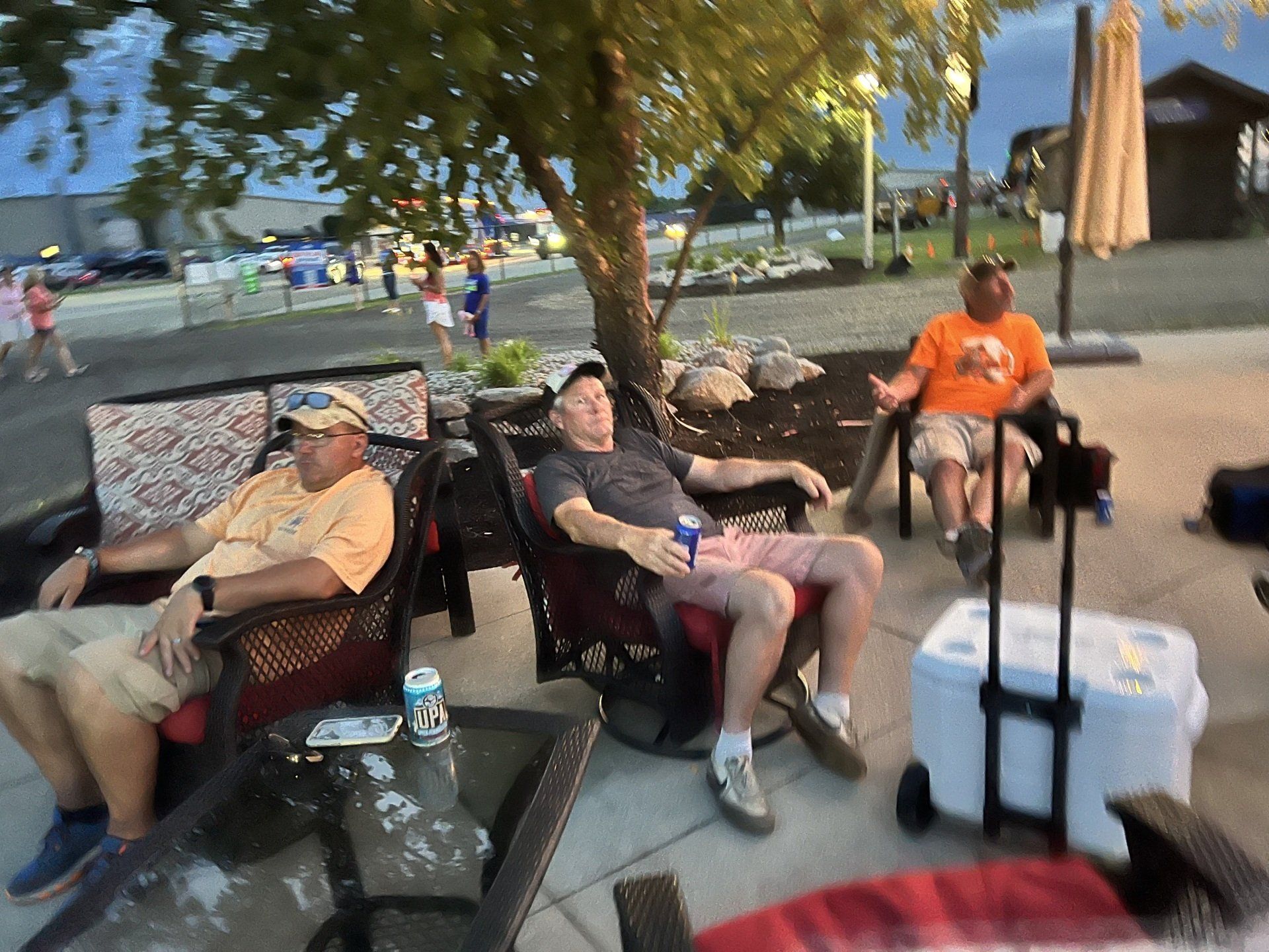 A group of men are sitting around a fire pit