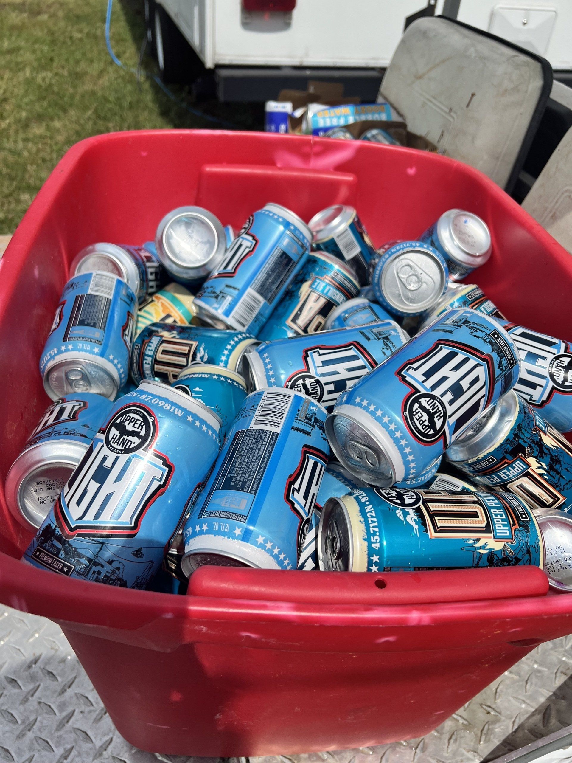 A red bin filled with cans of light beer
