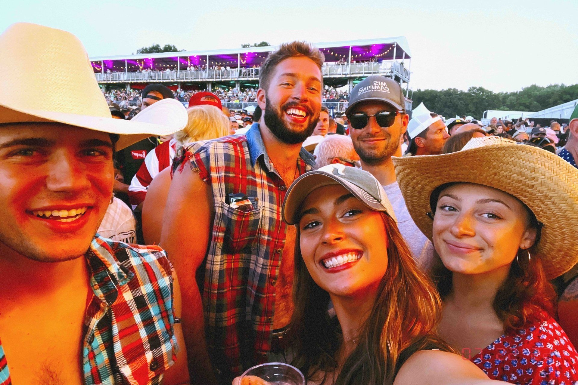 A group of people are posing for a picture at a concert.