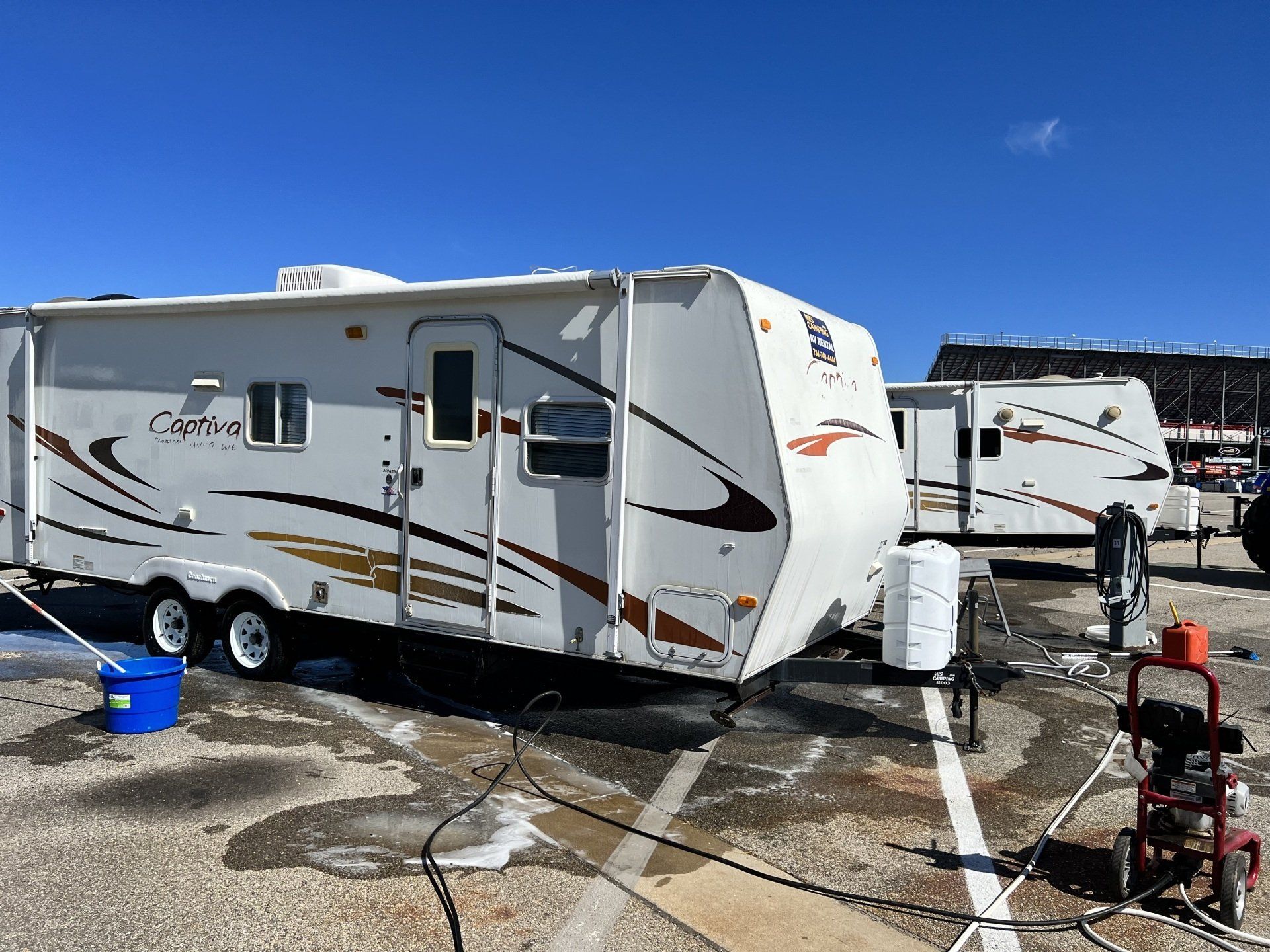 A couple of rvs are parked next to each other in a parking lot.