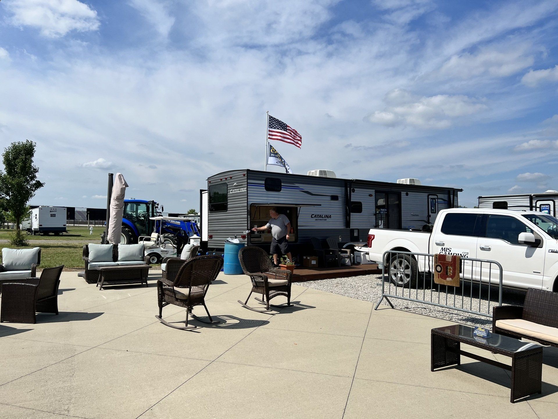 A man is standing in front of a rv parked in a parking lot.