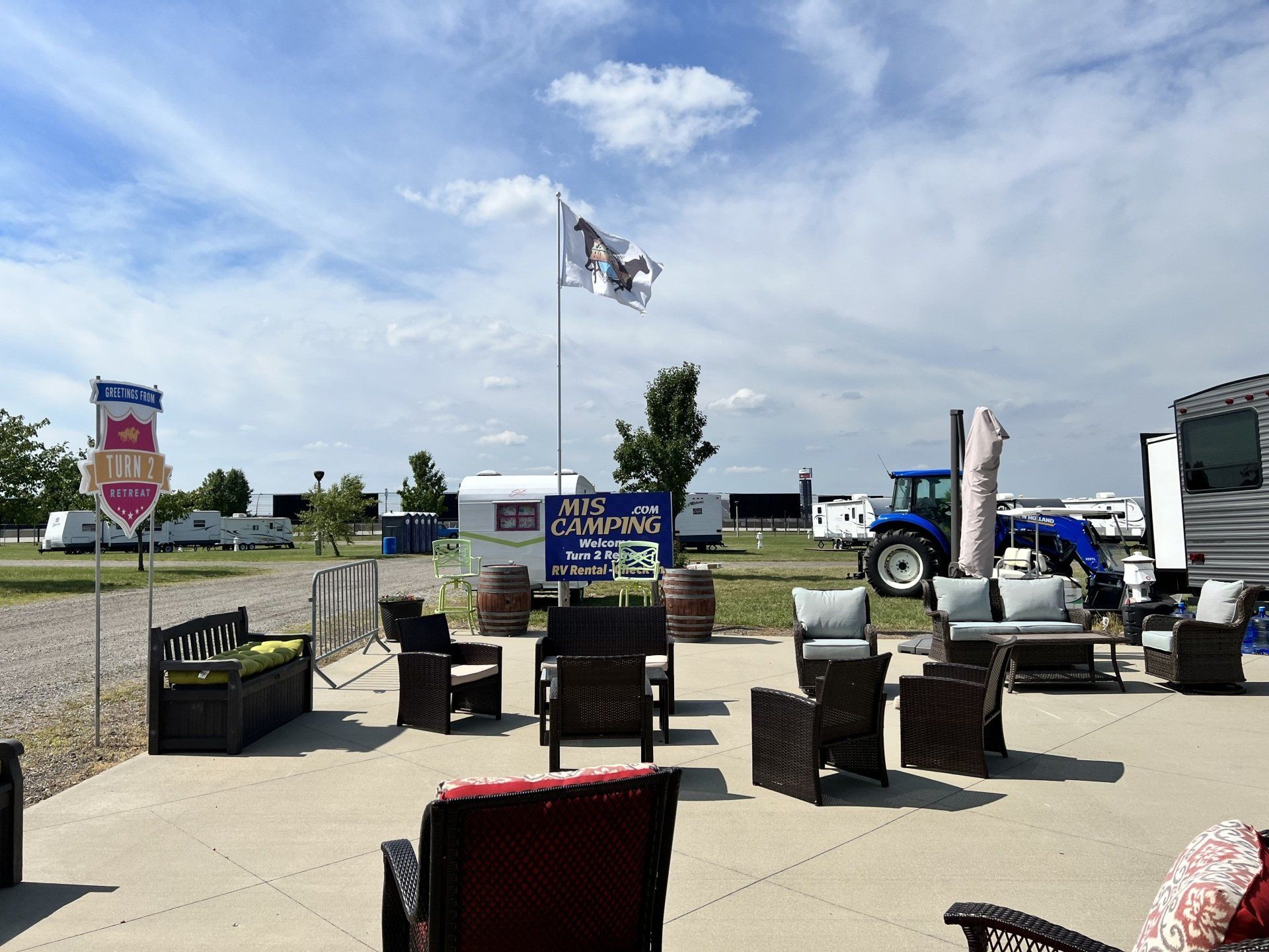 A patio with a lot of furniture and a tractor in the background.