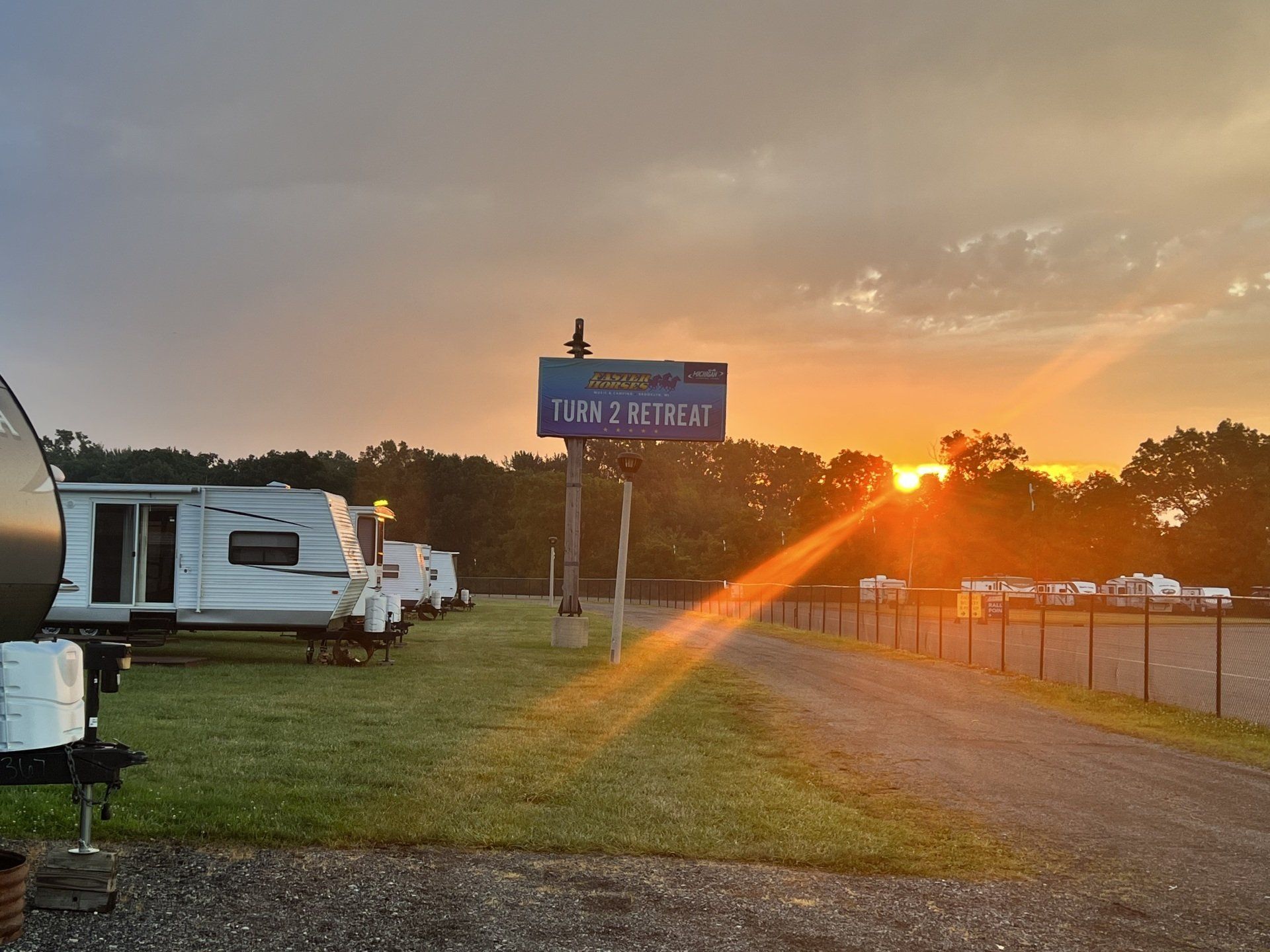 The sun is setting behind a sign that says rv retreat