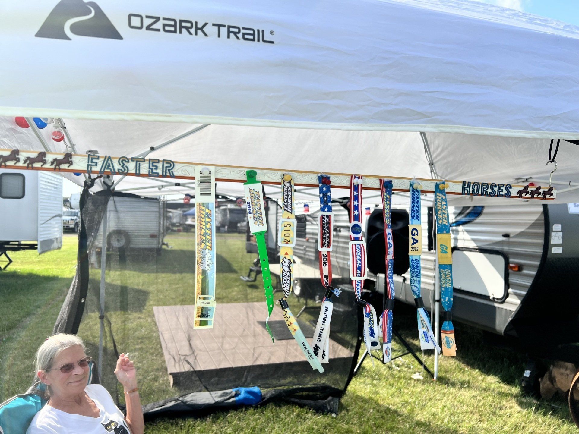 A woman is sitting under a canopy with skis hanging from it.
