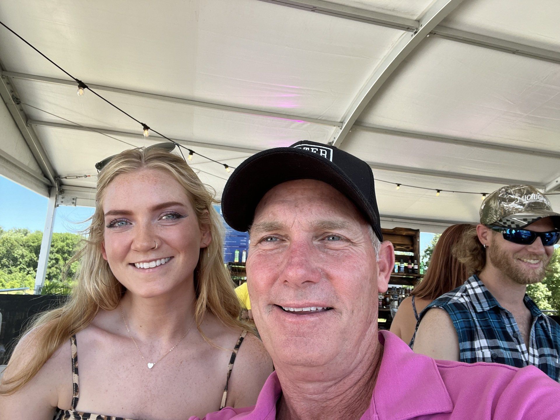 A man and a woman are posing for a picture in a tent.