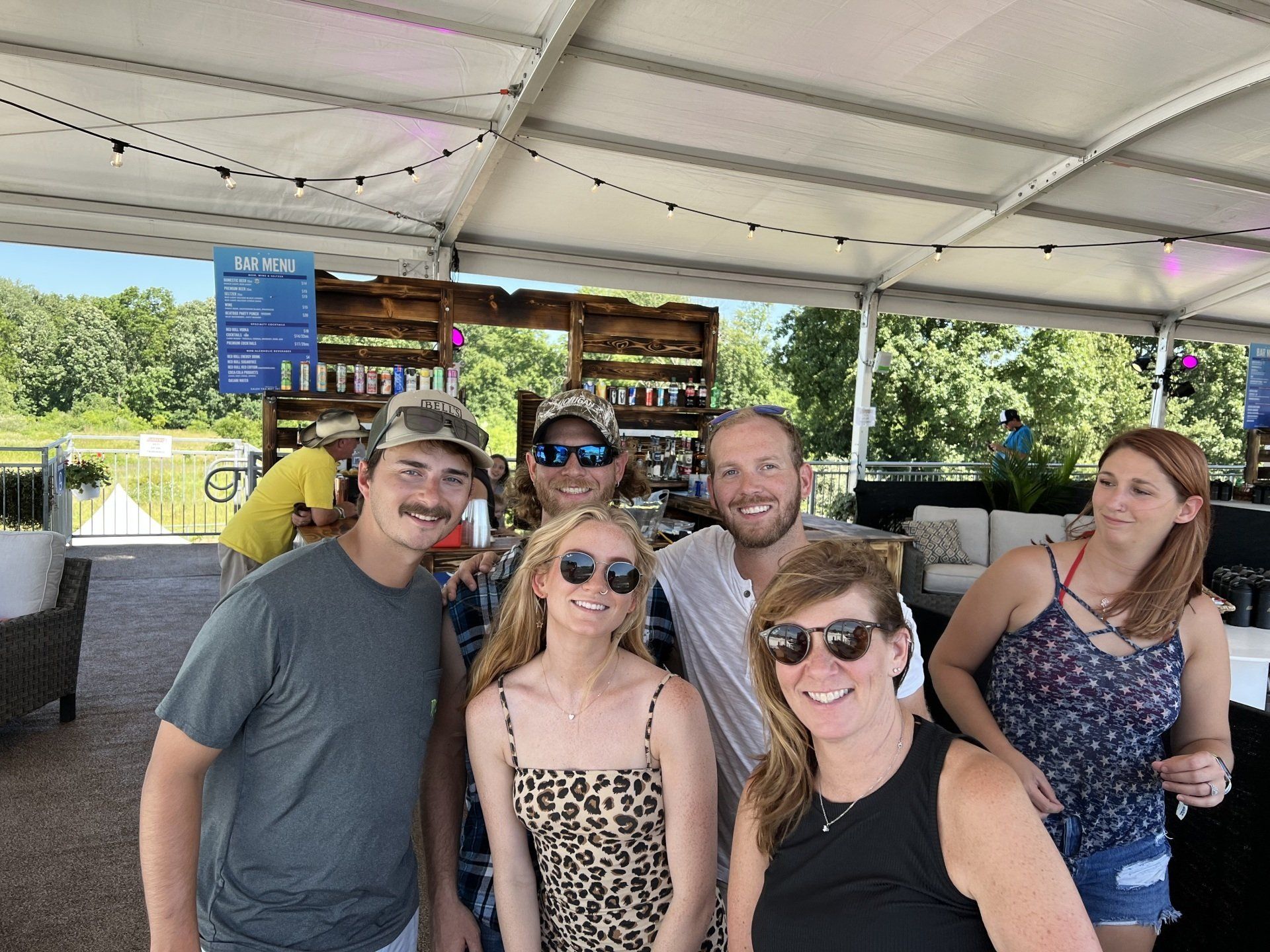 A group of people are posing for a picture in a tent.