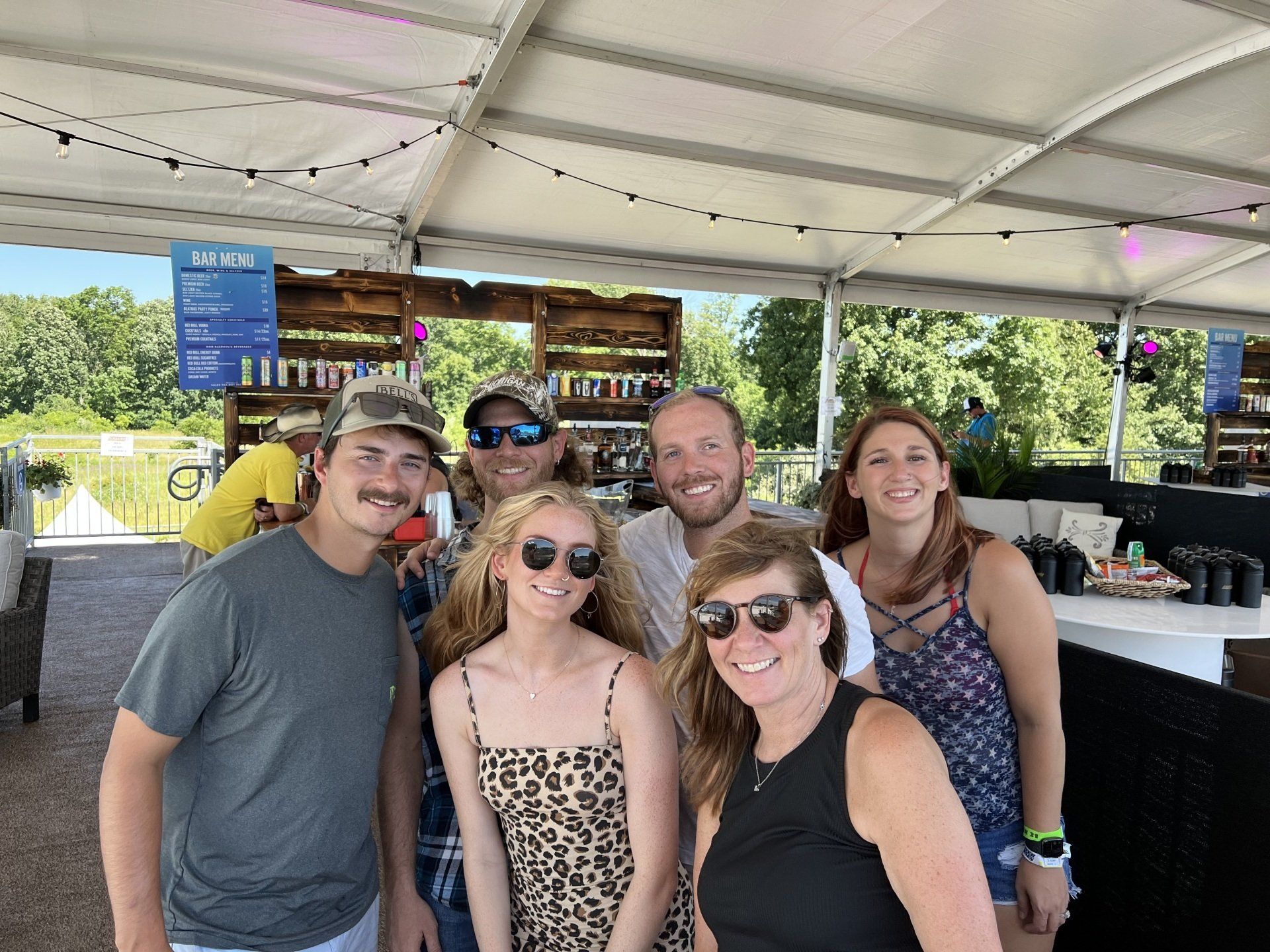 A group of people are posing for a picture in front of a tent.