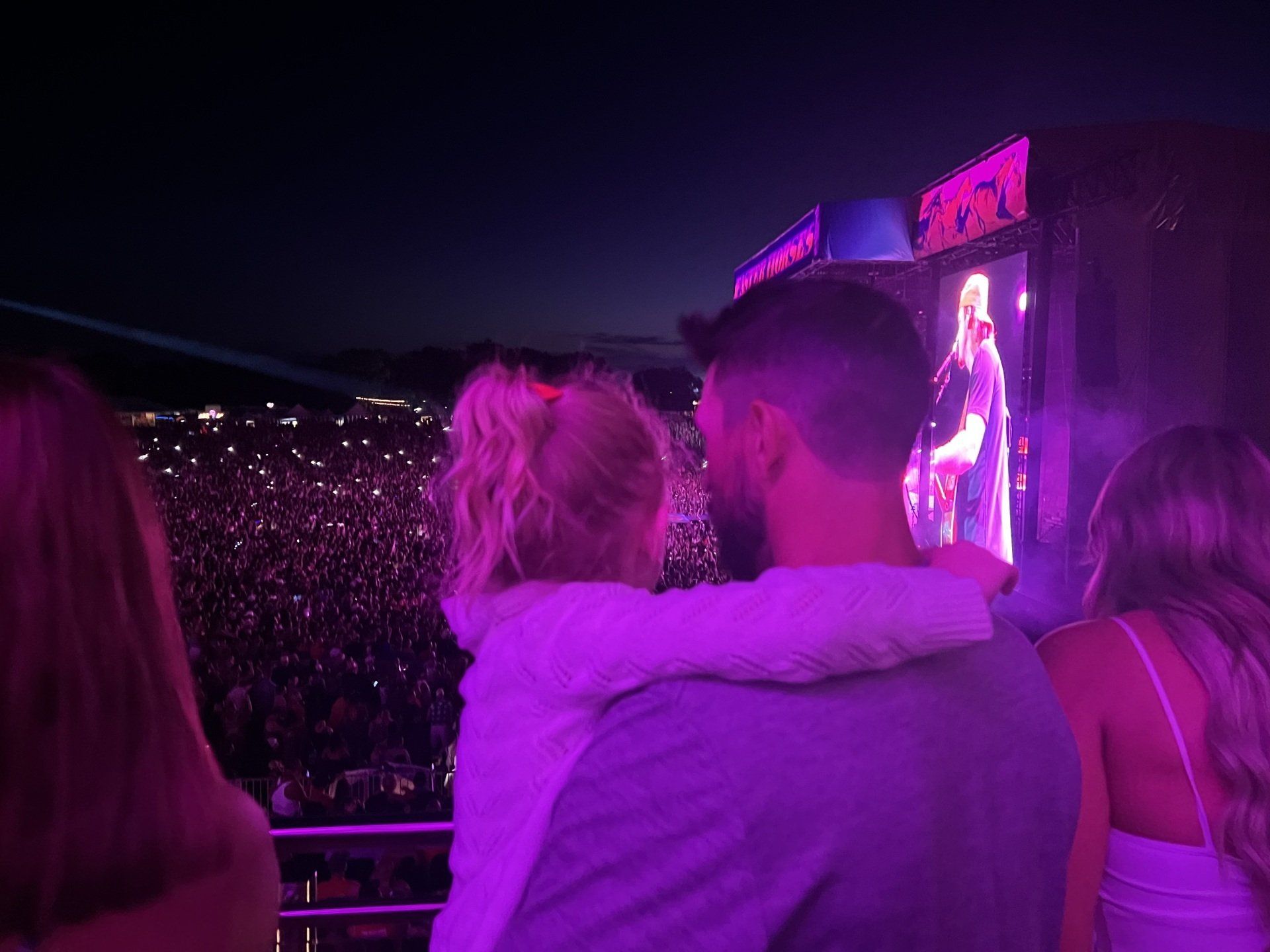 A man and a little girl are watching a concert at night.