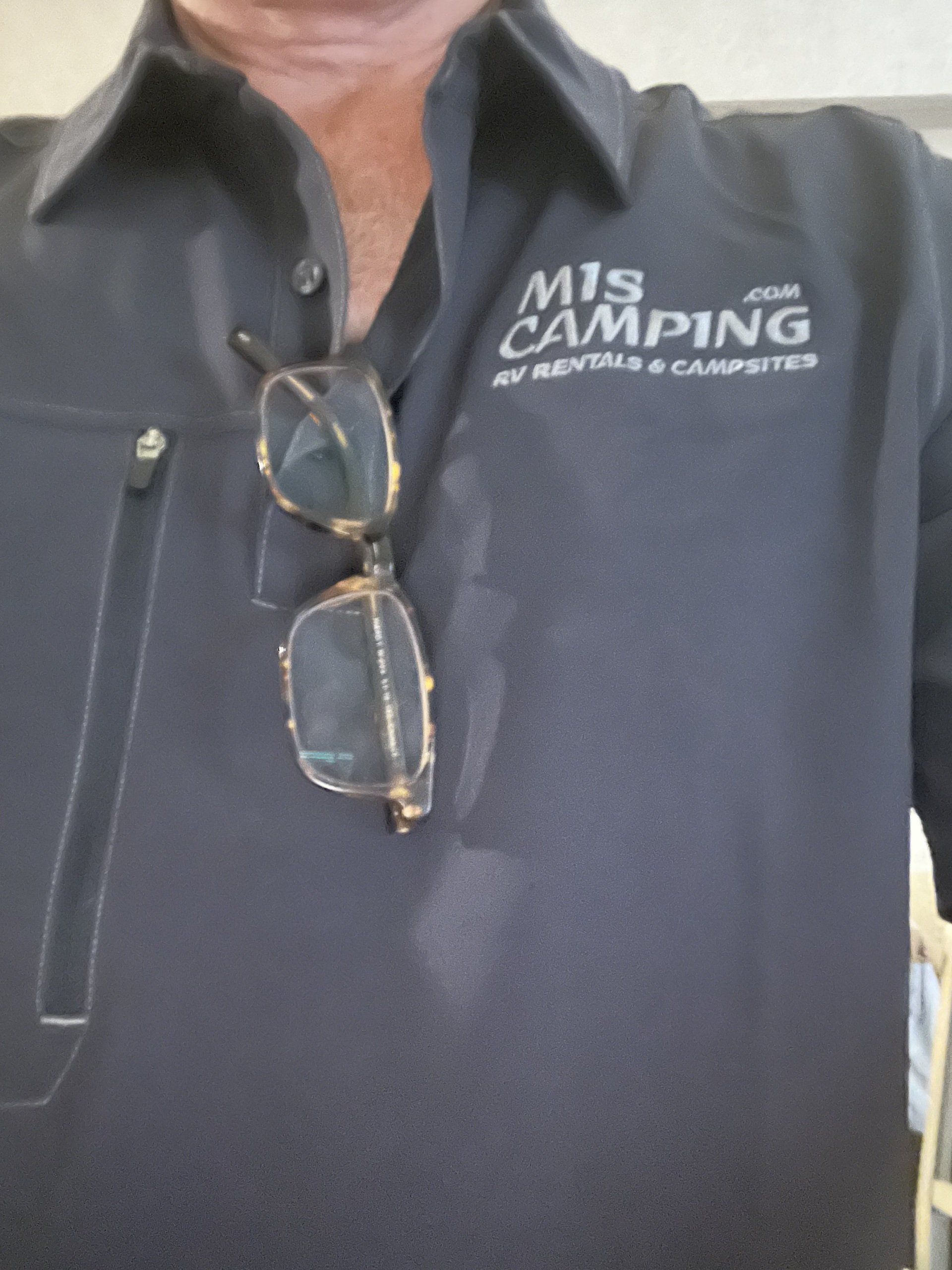 A man wearing a shirt that says mis camping
