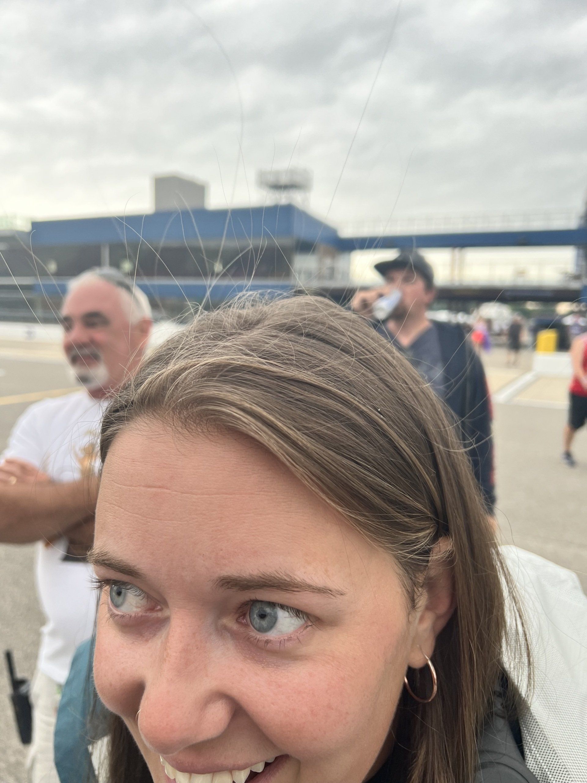 A close up of a woman 's face with a man in the background.