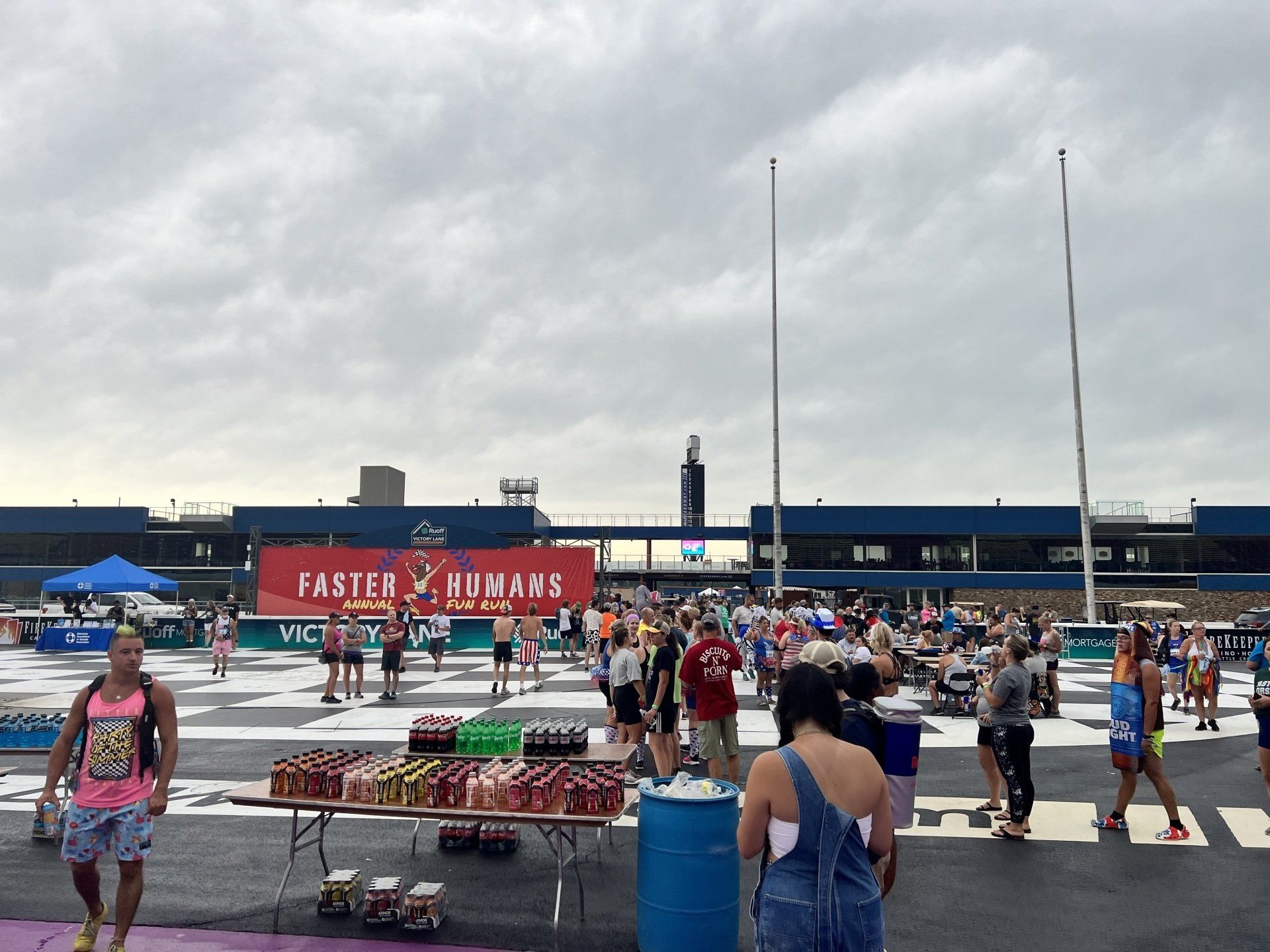 A crowd of people are gathered in front of a building that says faster hungry 's