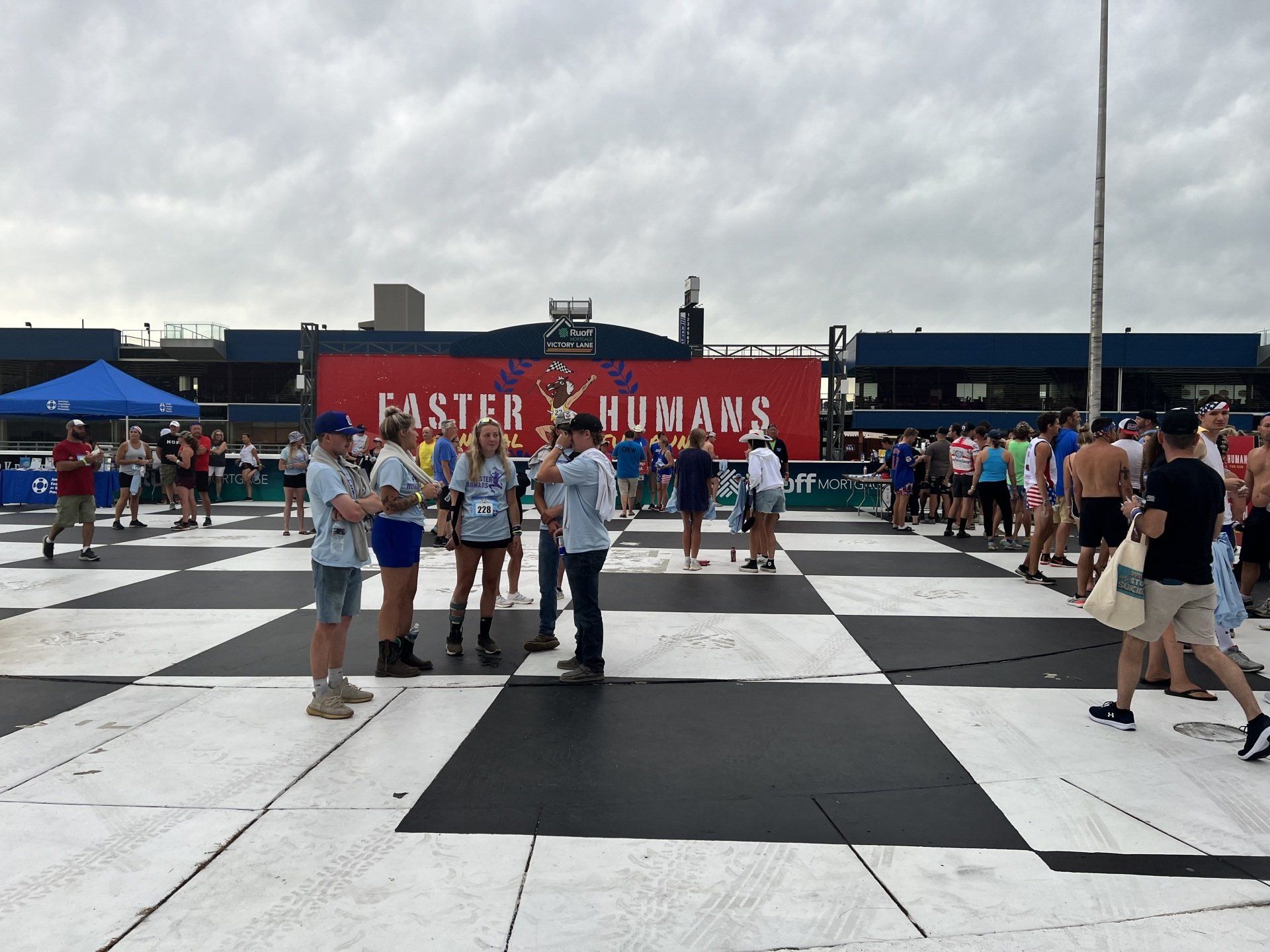 A group of people standing in front of a sign that says faster humans