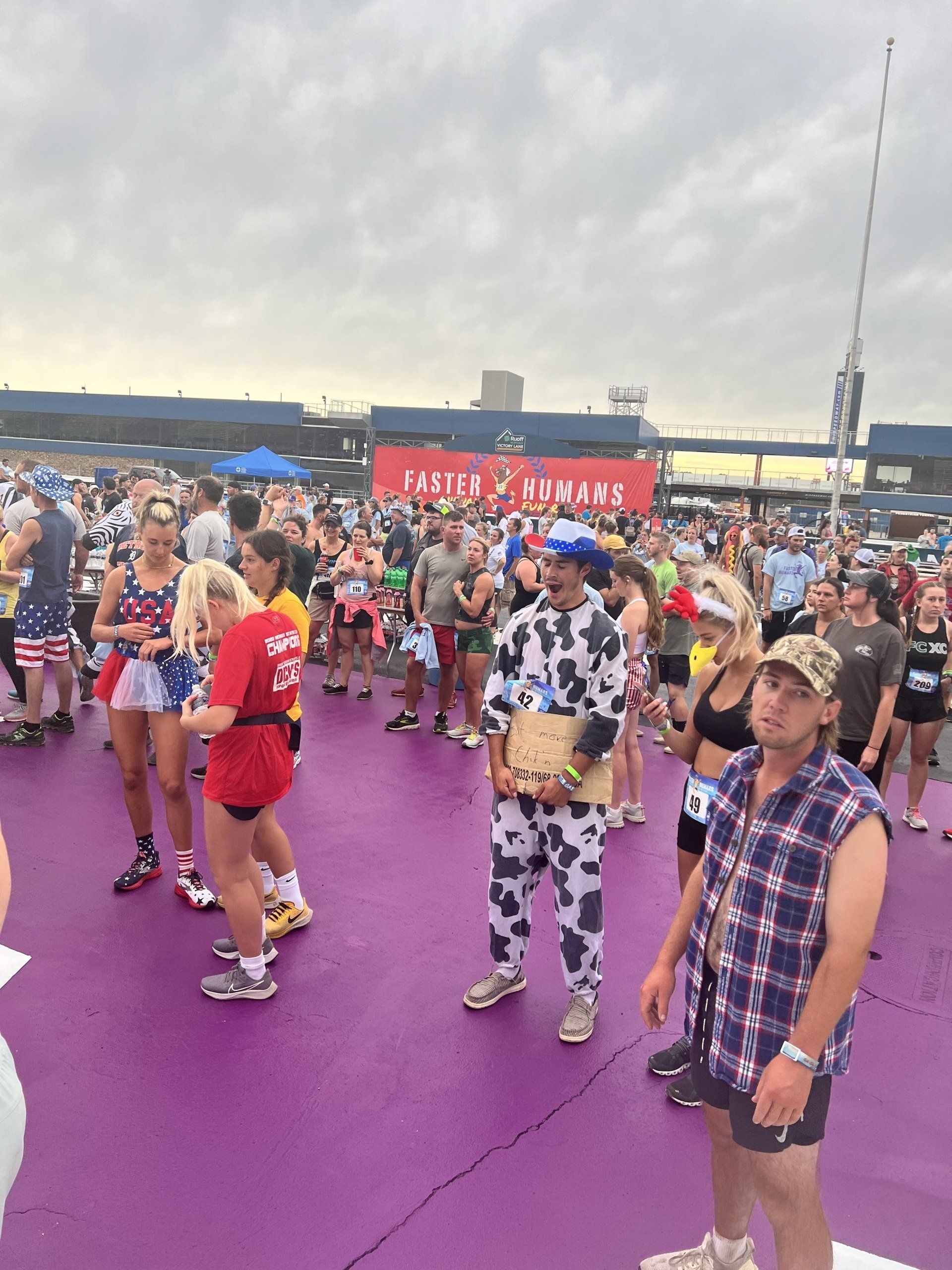 A man in a cow costume is standing in a crowd of people