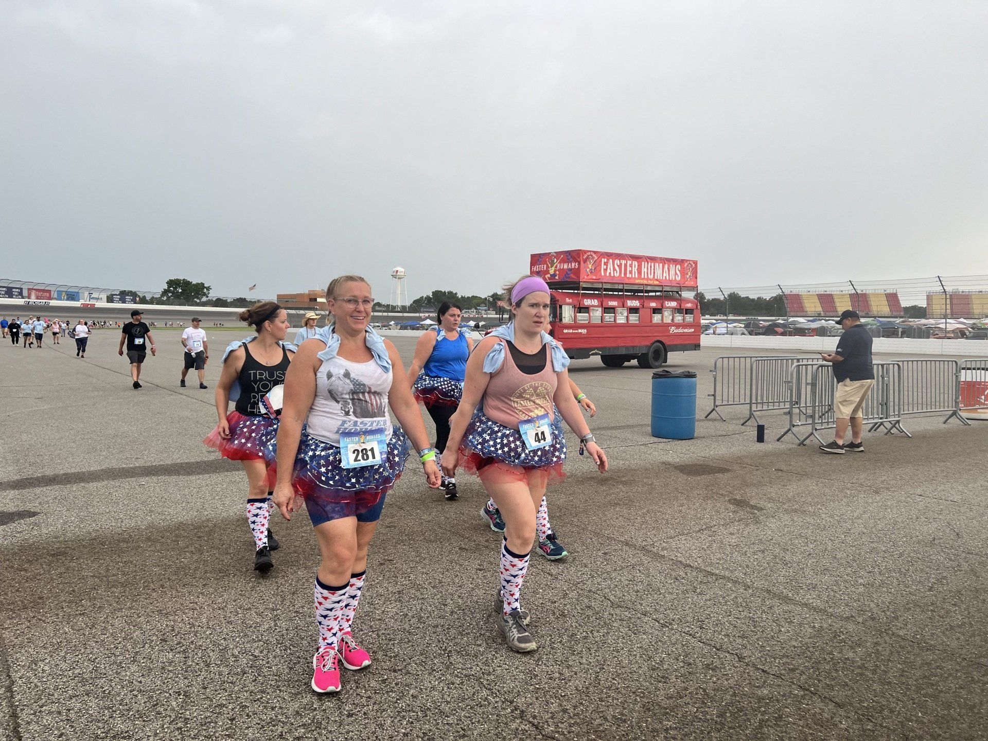 A group of women are walking down a road.