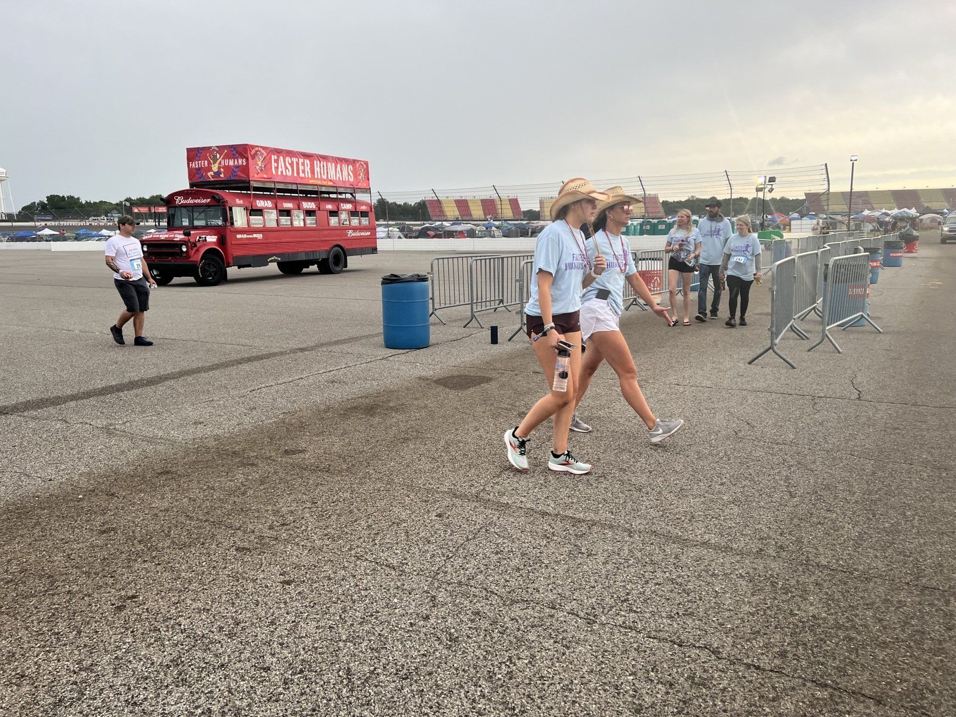 A group of people are walking down a gravel road.