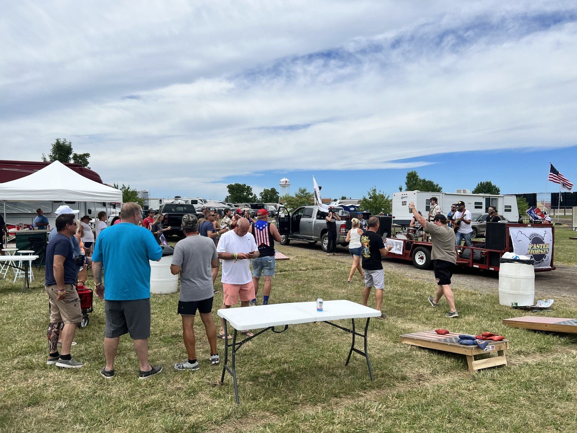 A group of people are standing around a table in a field.
