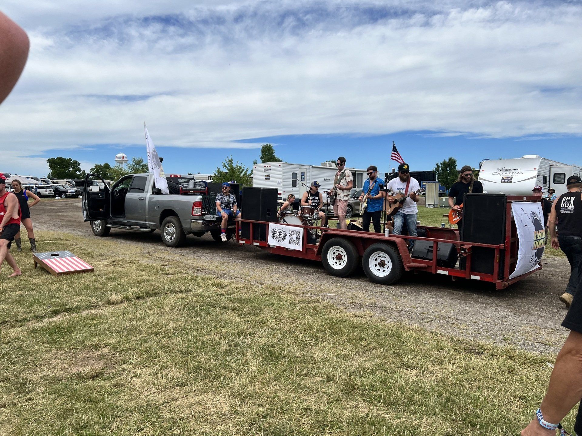 A group of people are sitting on a trailer in a field.