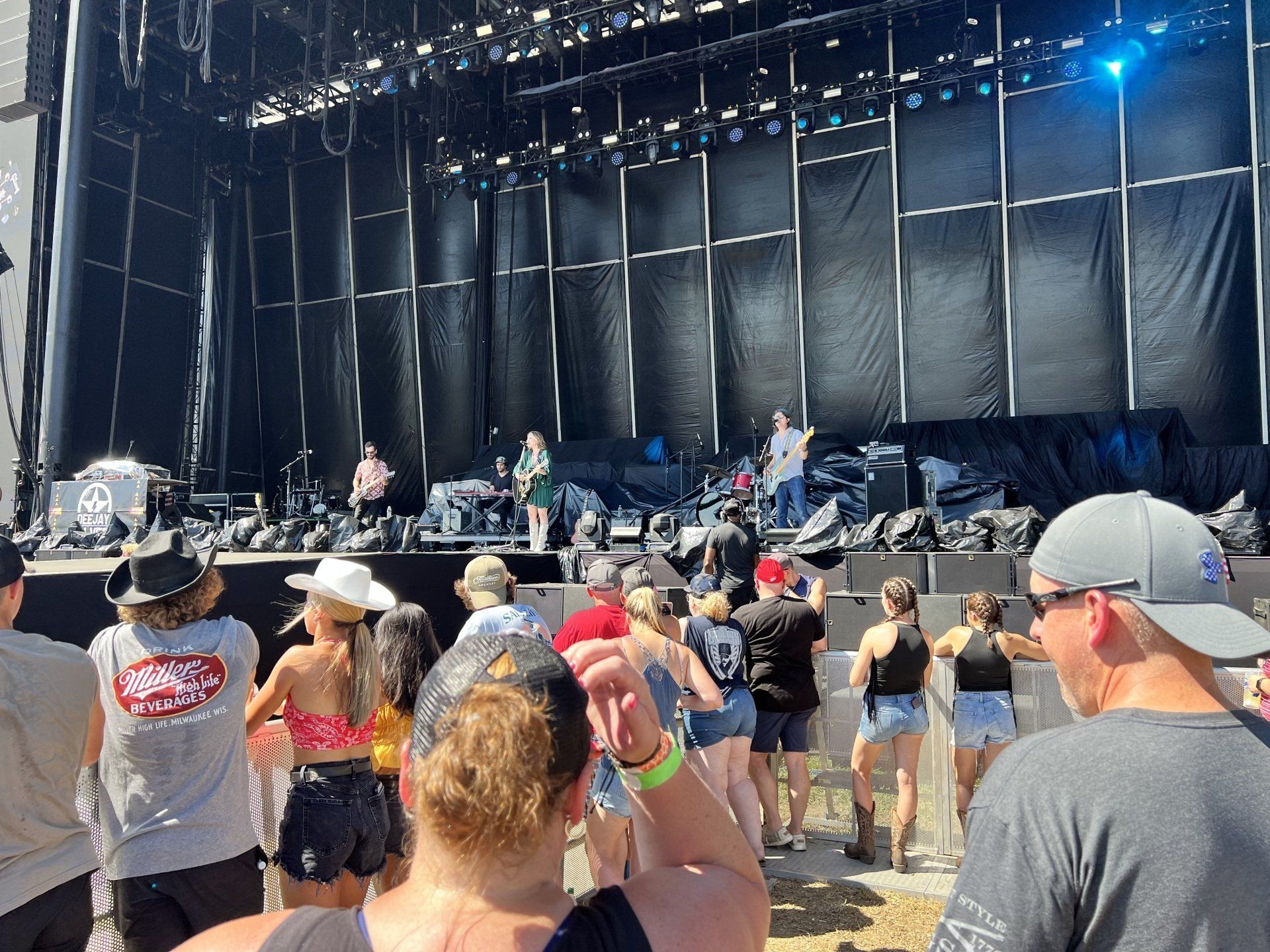 A group of people are standing in front of a stage at a concert.